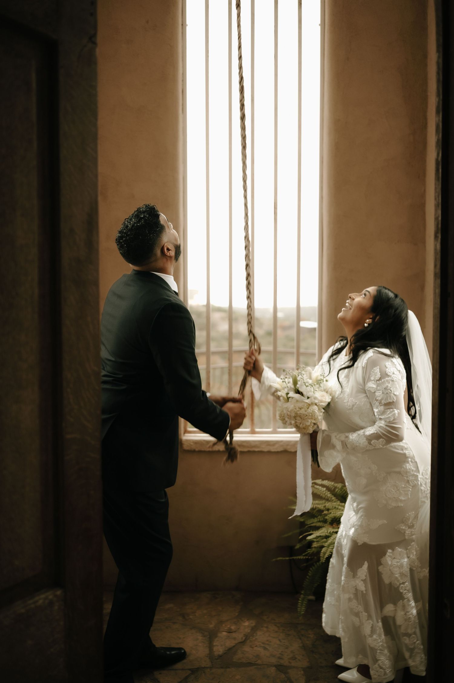 Artistic wedding photos capturing intimate moments between newlyweds by a window in sepia tones.