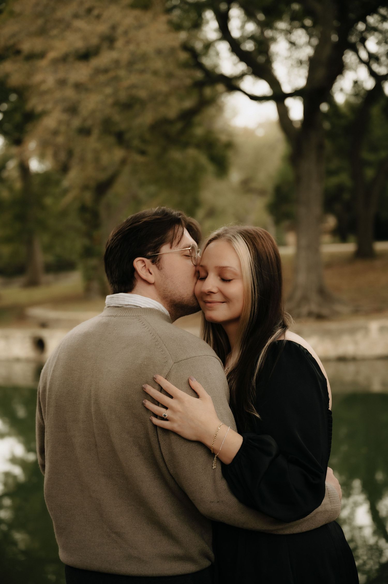 Intimate engagement photos captured in a park setting during golden hour.