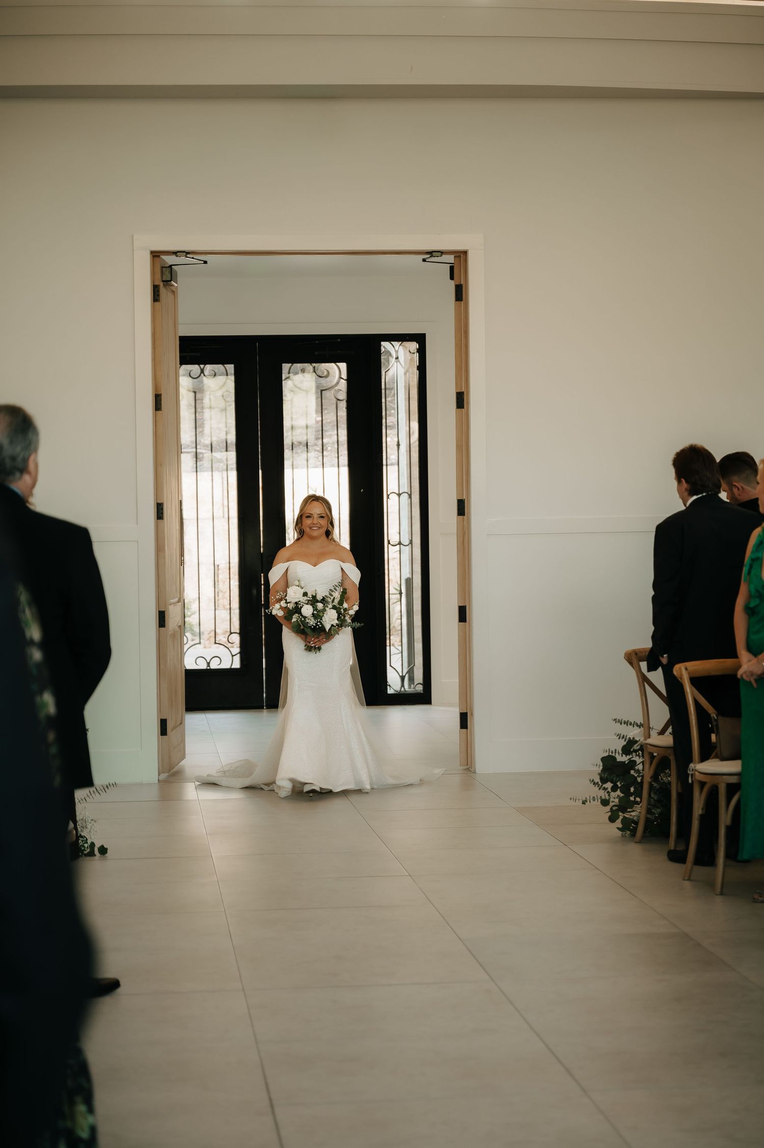 Minimalist wedding venue entrance with black doors and white walls.
