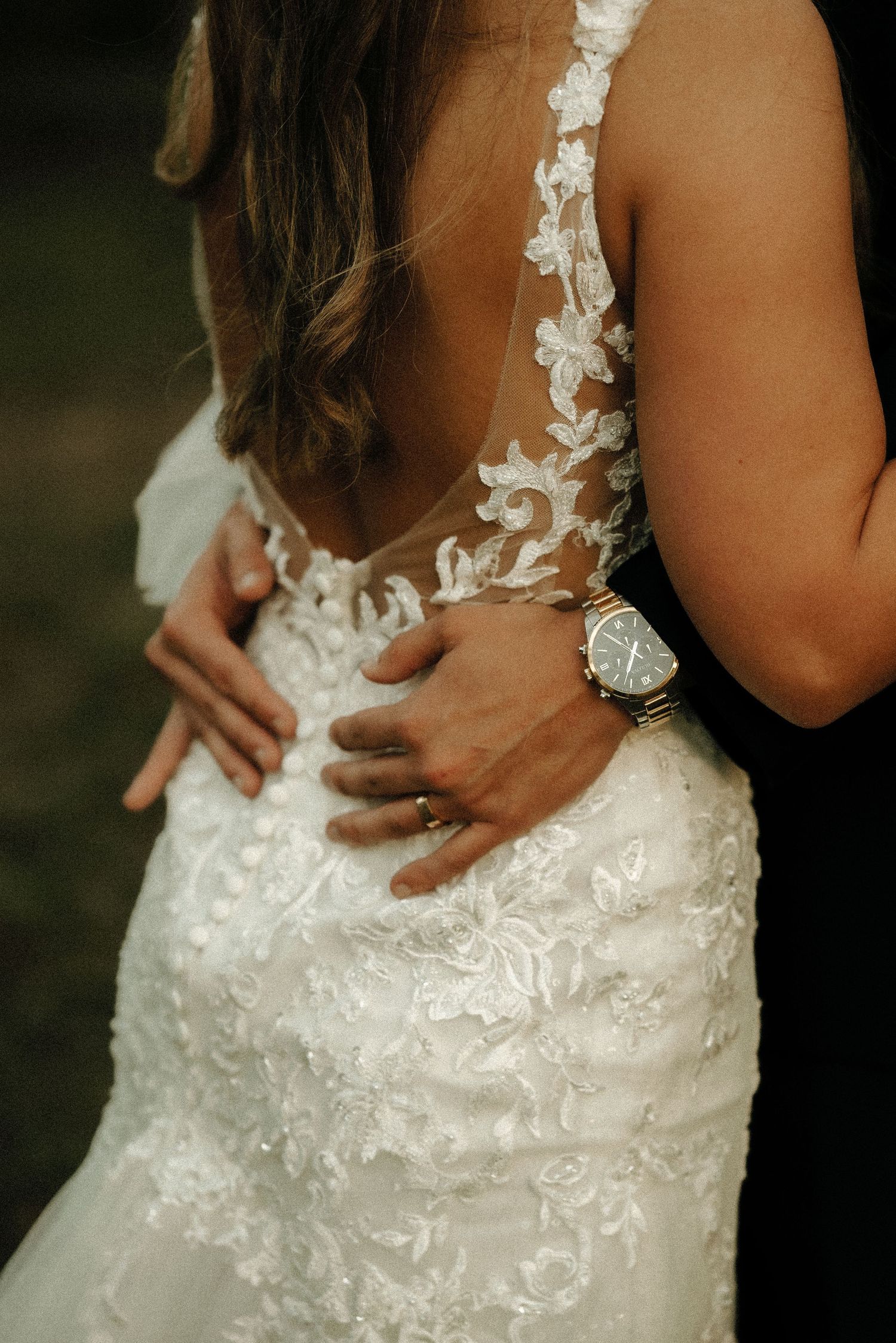 Close-up details of intricate lace and beading on a white wedding dress.