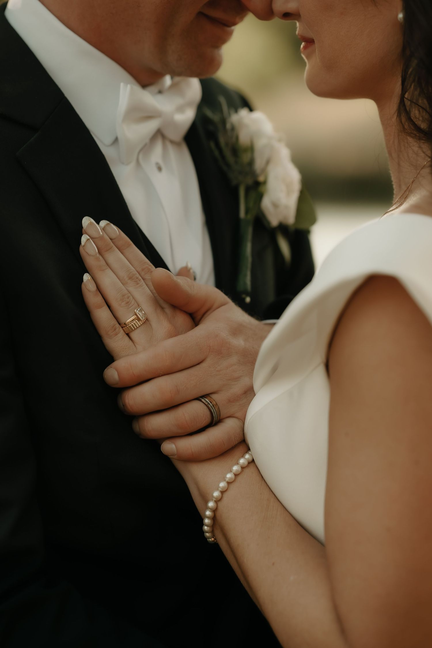 Close-up details of wedding rings and hands during an intimate moment.