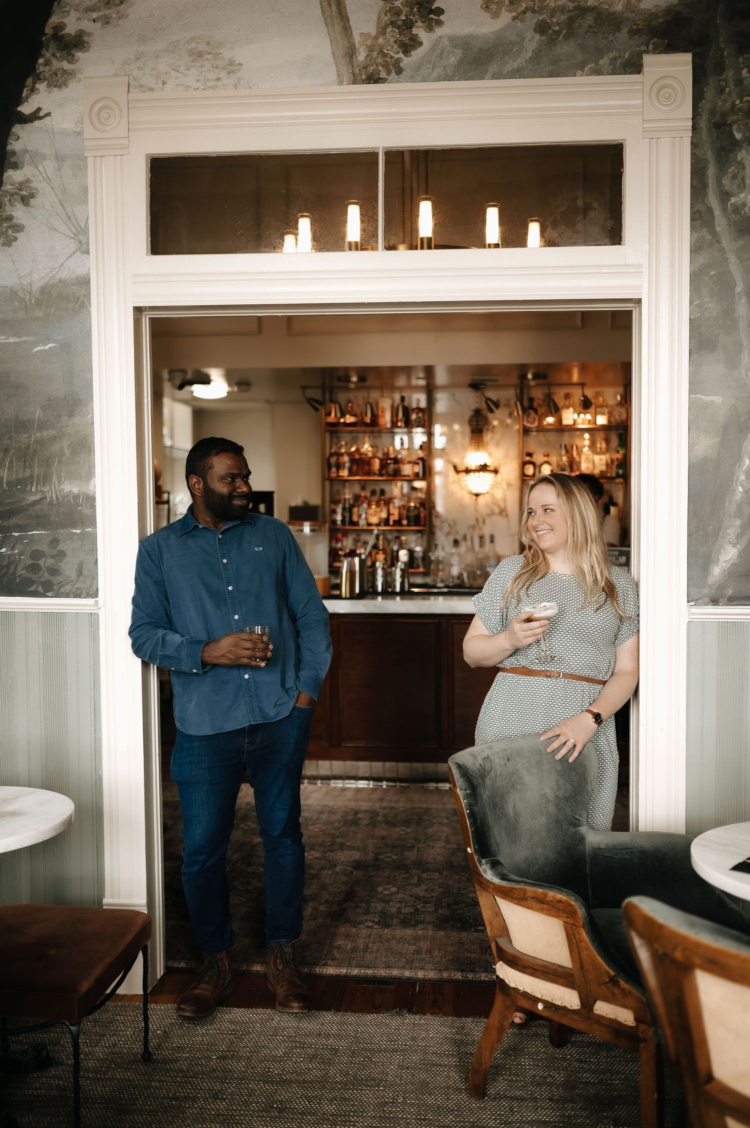 Couple enjoying conversation in cozy bar setting with vintage decor.