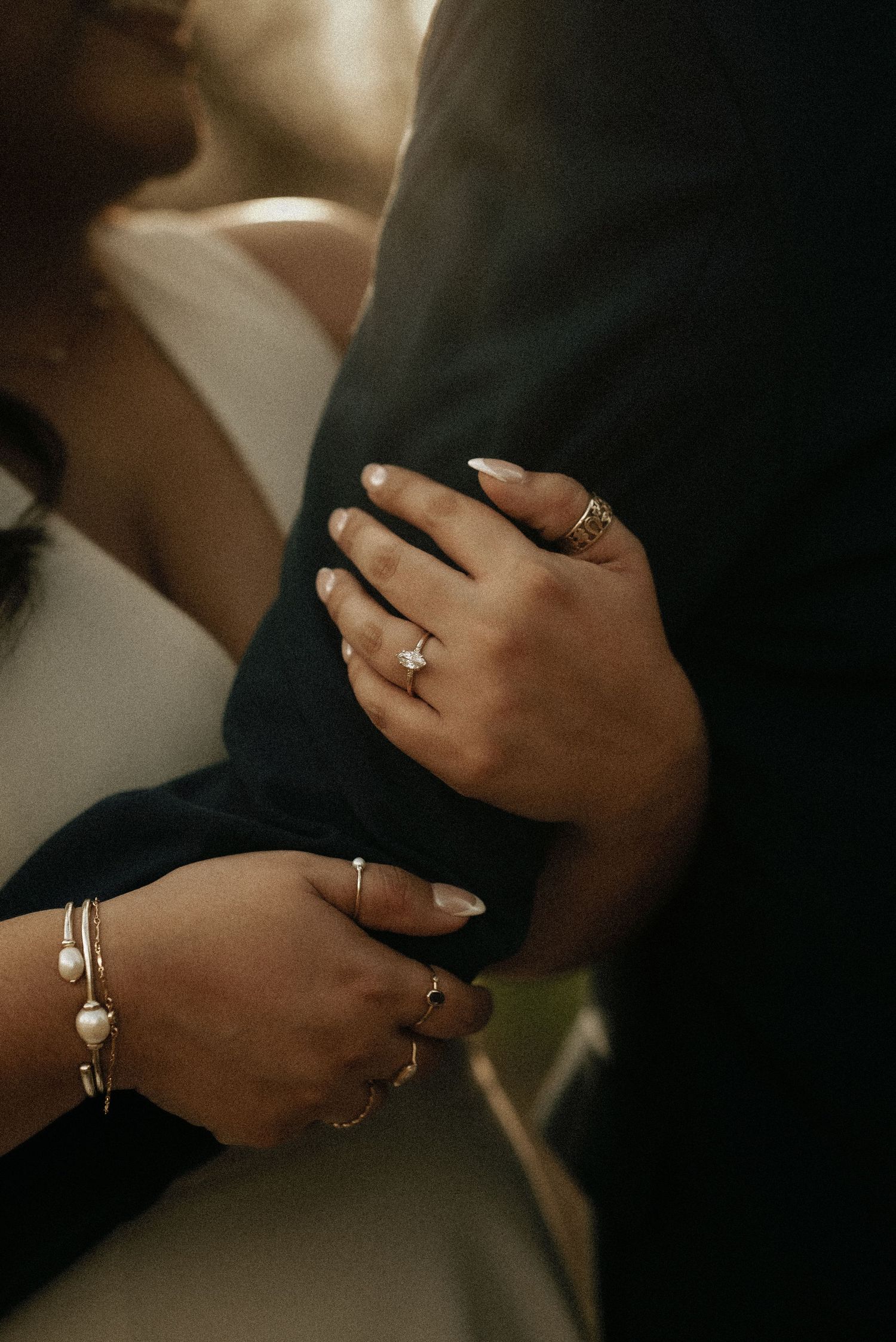 Close-up of hands with rings and jewelry during an intimate moment.