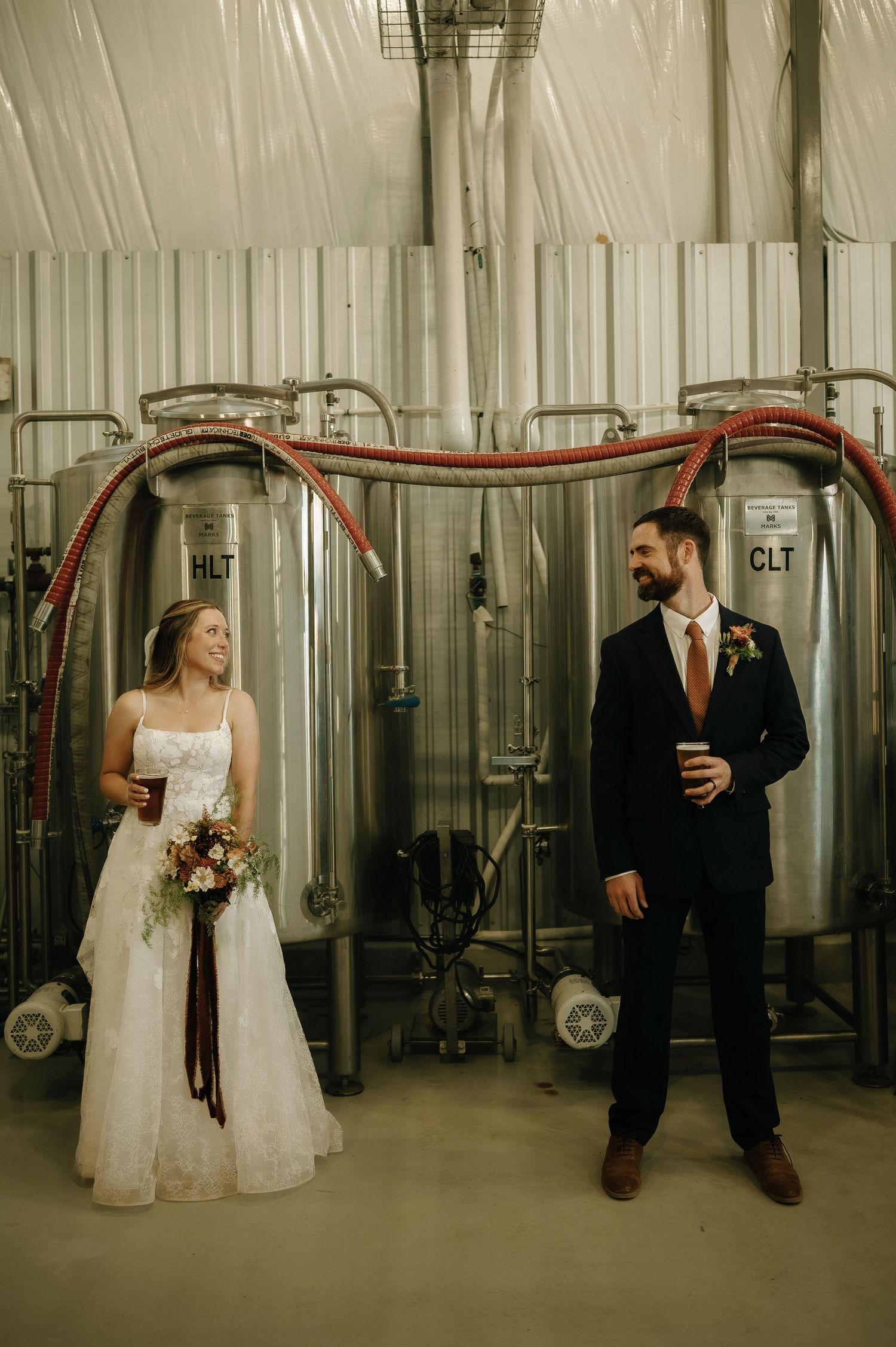 Wedding couple shares playful moments in an industrial warehouse setting.