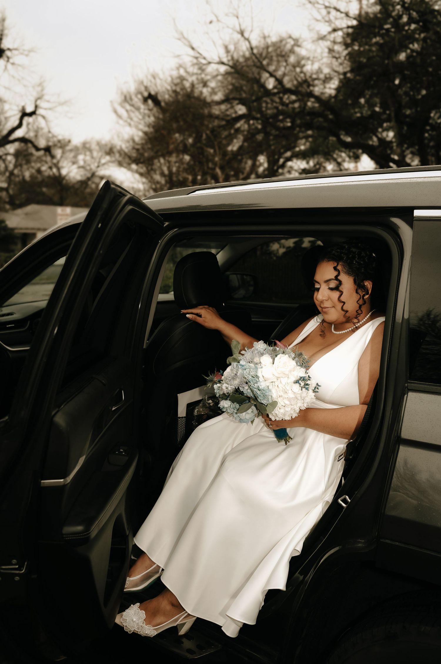 Newlyweds sharing a private moment in the back of a limousine after their ceremony.