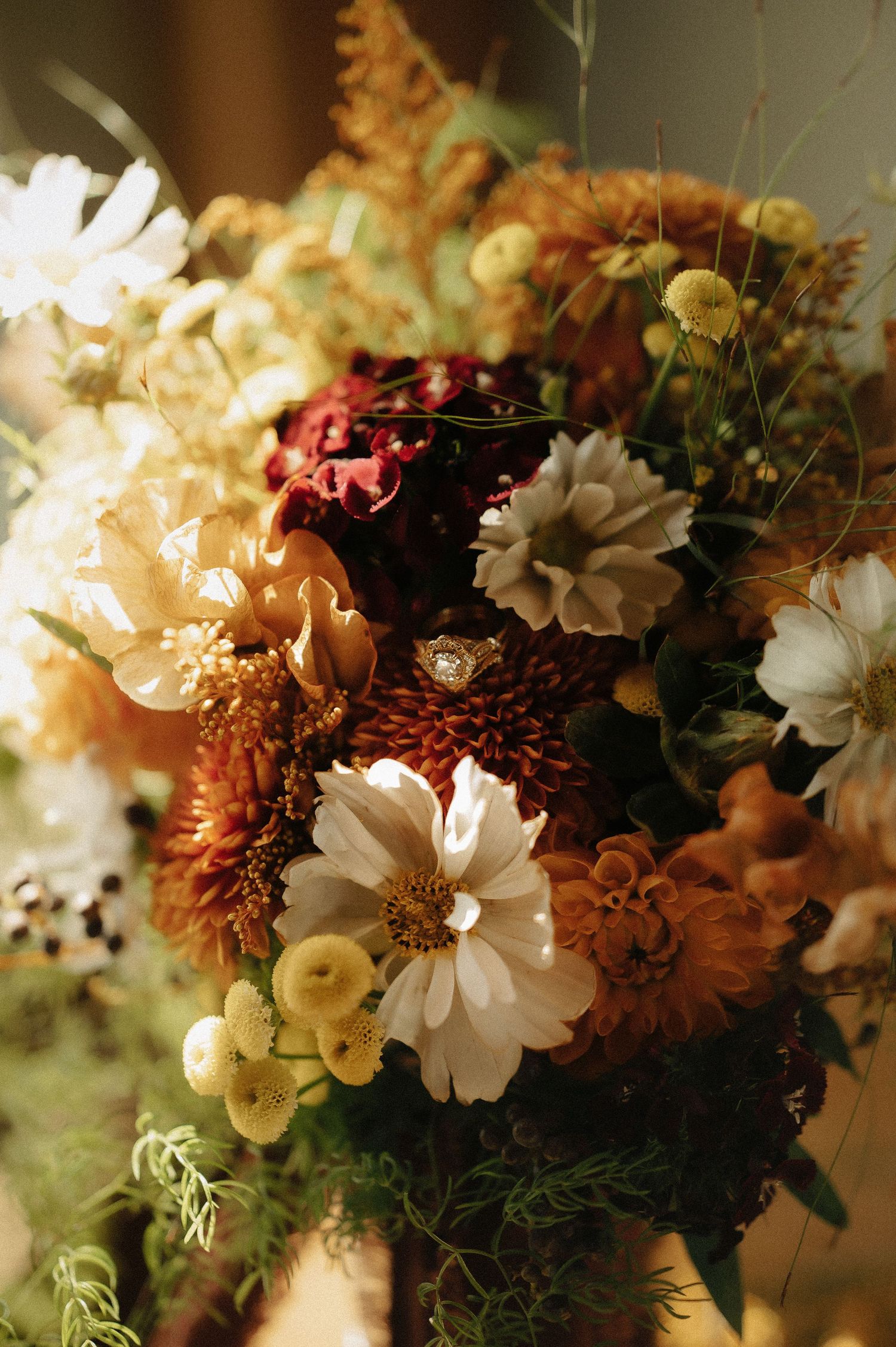 Autumn wedding floral arrangement with white daisies and warm-toned blooms.