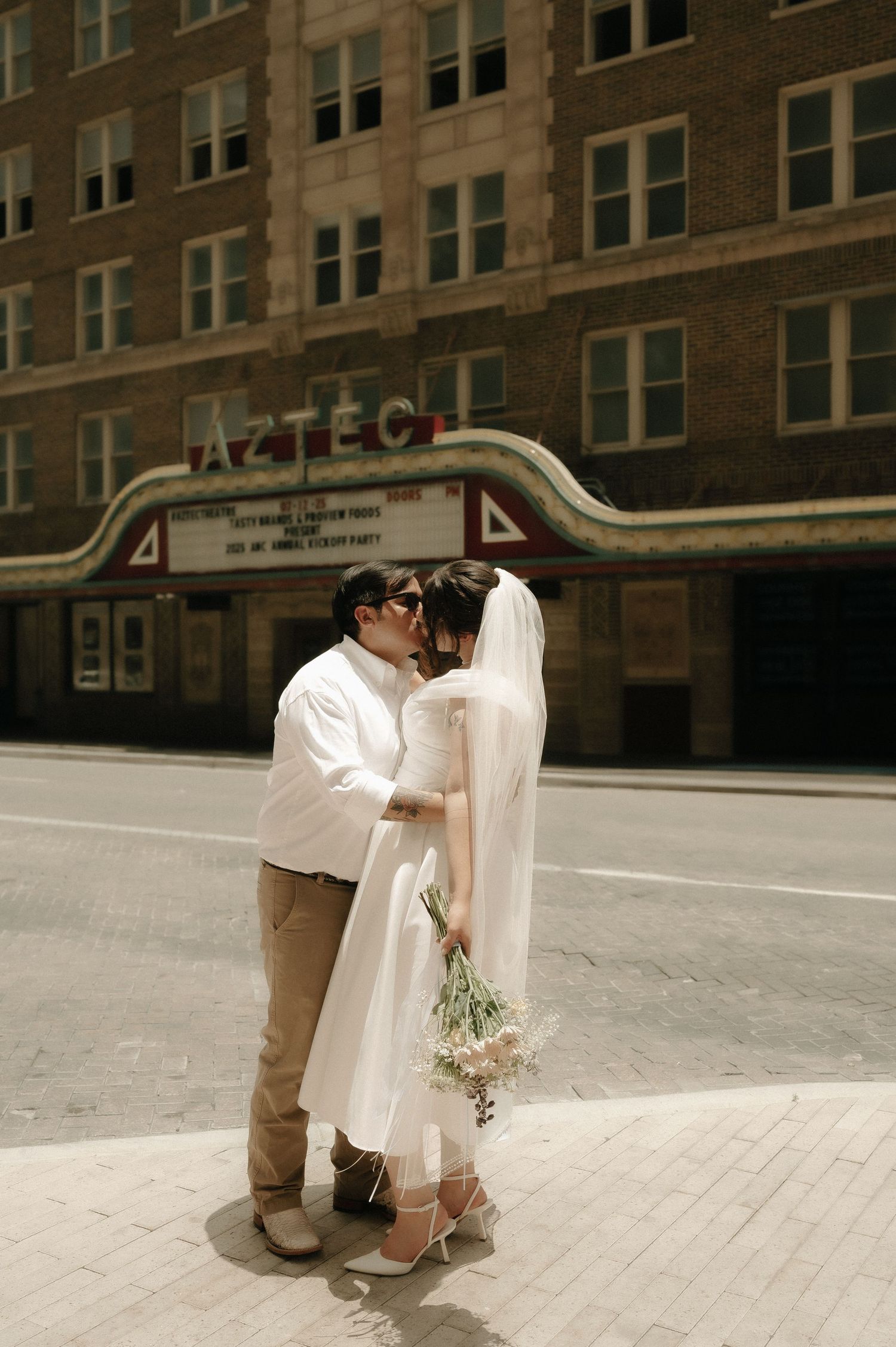 A series of urban wedding photos with a couple posing against a brick building backdrop.