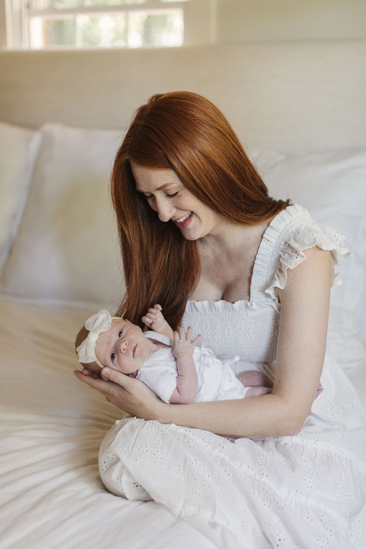 Intimate moments captured in white eyelet dresses against soft bedding.