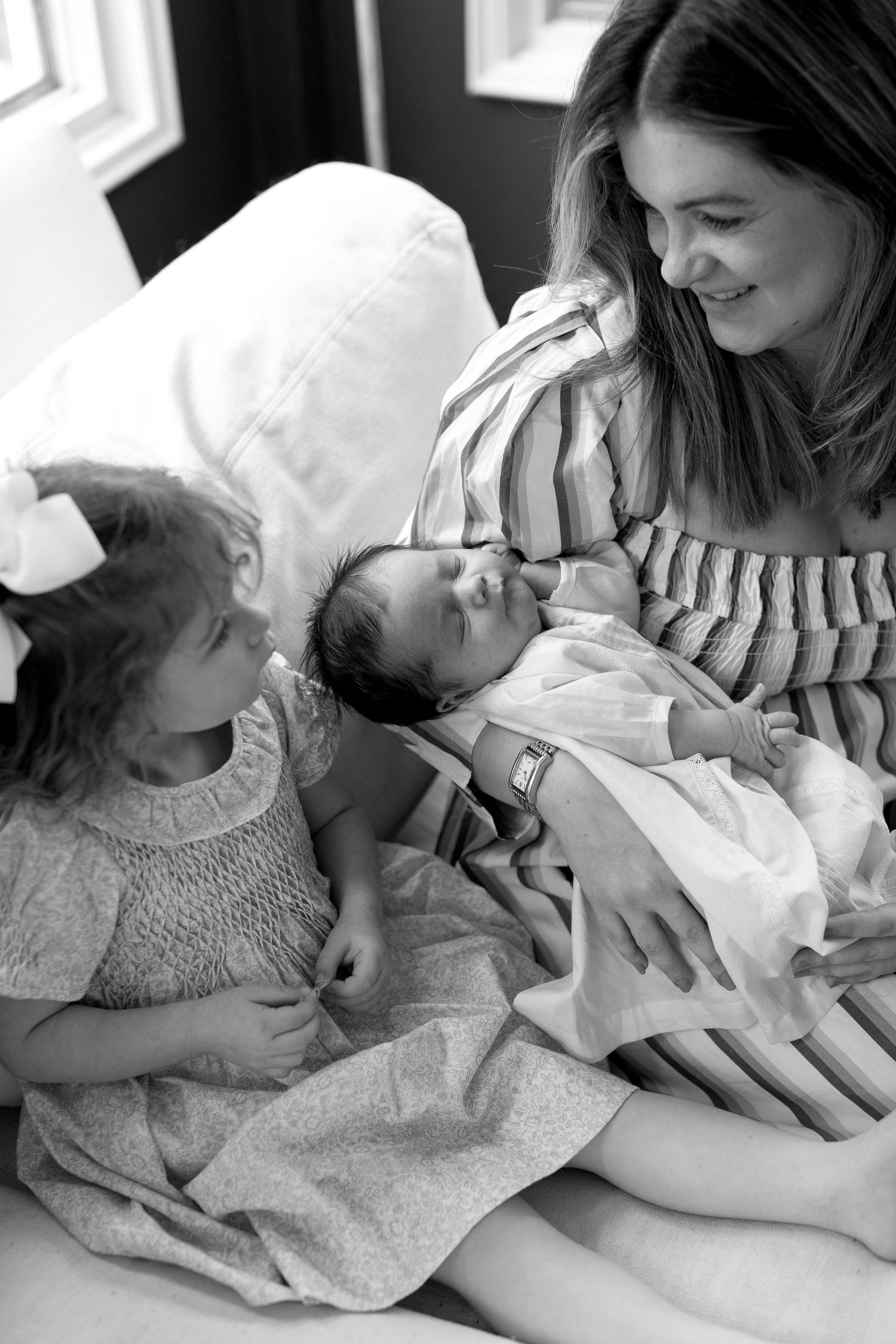 Black and white photos show tender moments between parents and newborn baby in hospital.