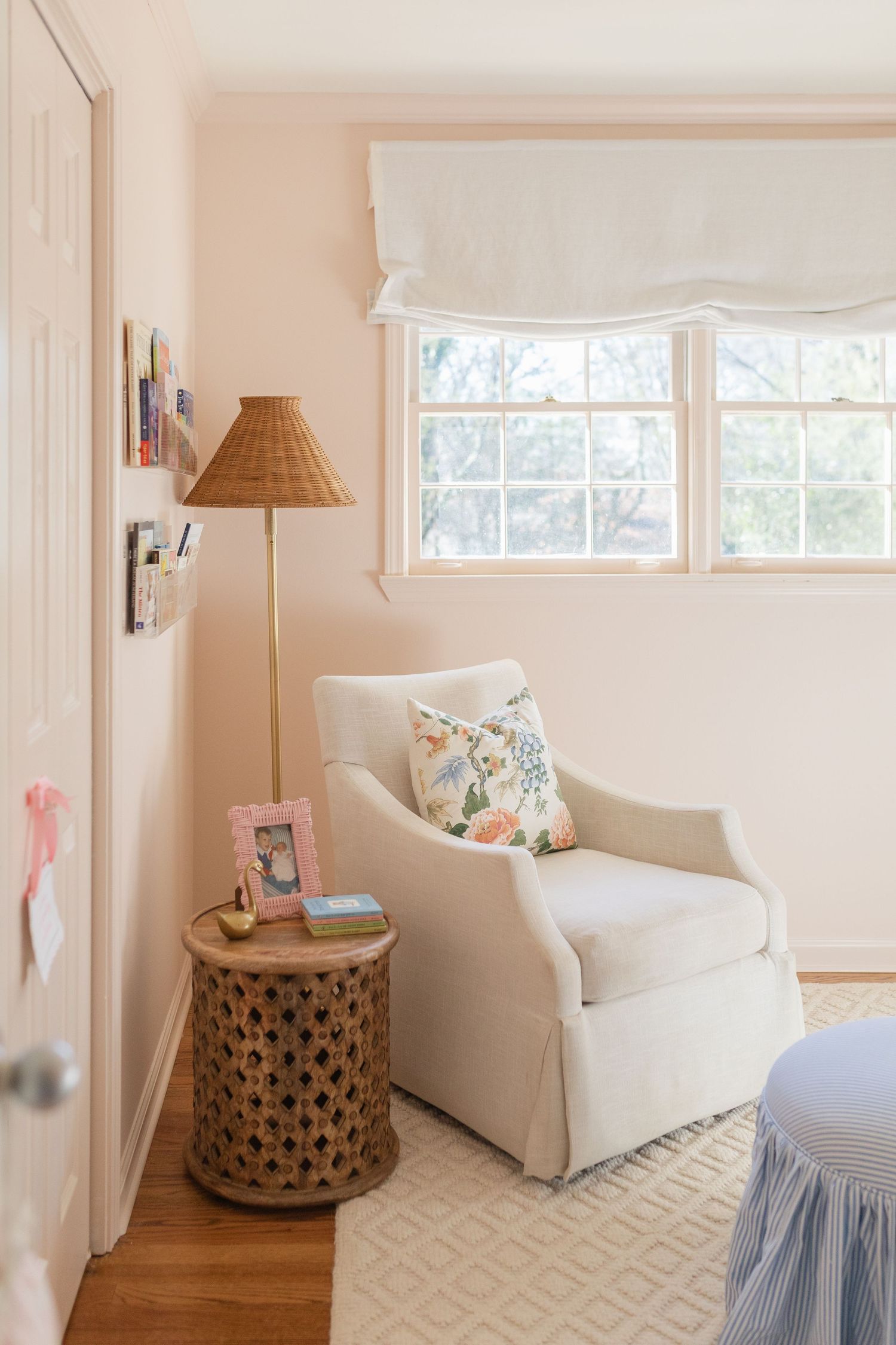 Bright coastal living room with white sofa, rattan side table, and geometric patterned rug in neutral tones.