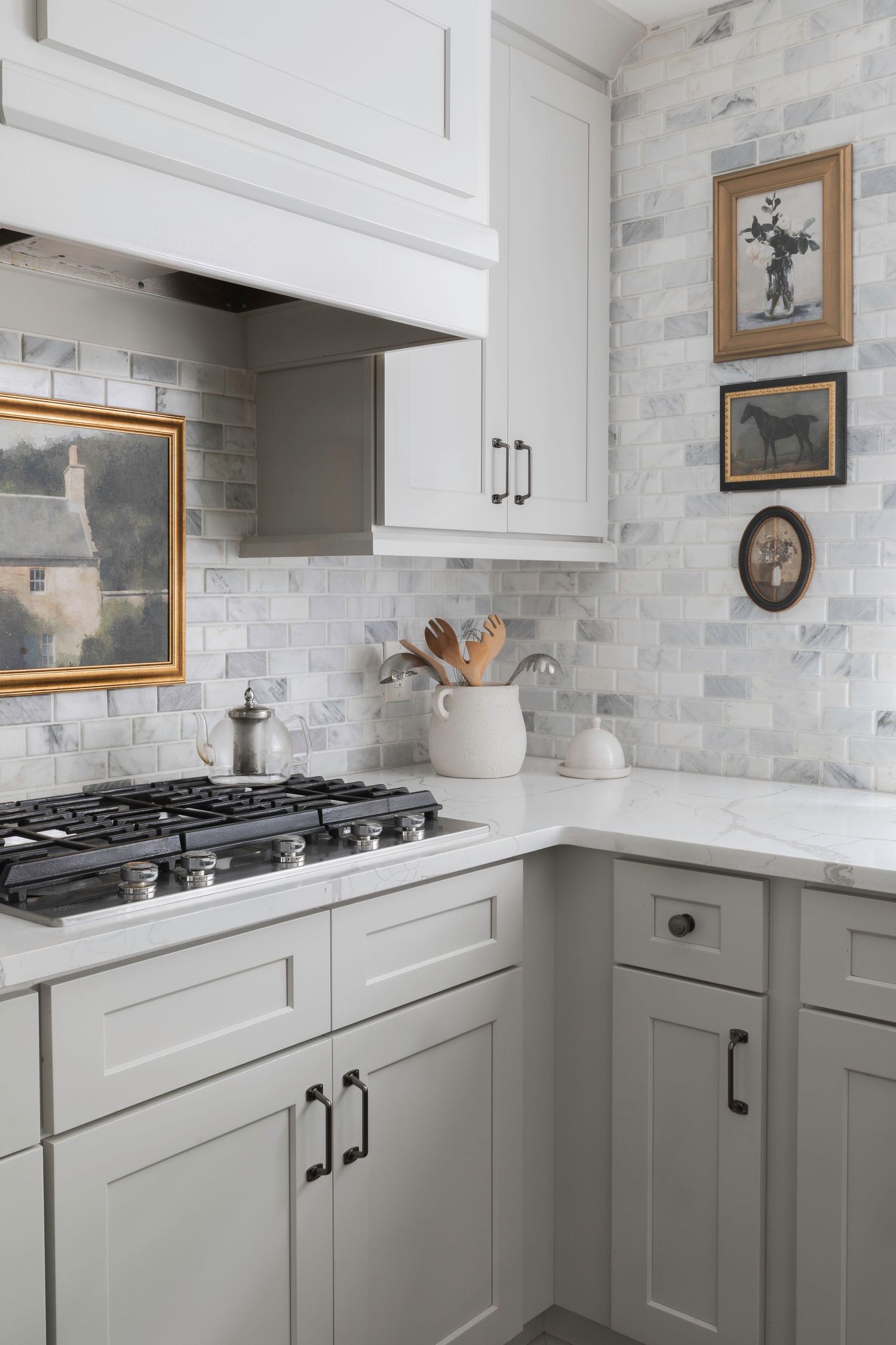 Classic white kitchen with marble backsplash, gray lower cabinets, and vintage artwork.  Atlanta Interior Design Photography