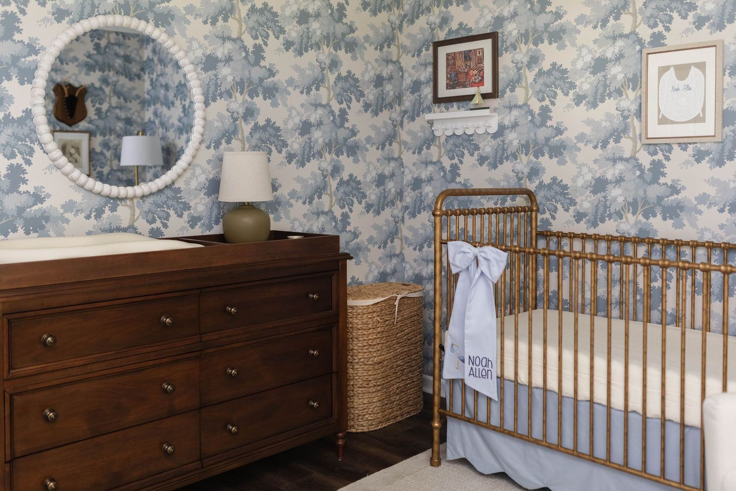 A classic nursery with blue toile wallpaper featuring a wooden dresser and crib - Atlanta Interior Design Photography
