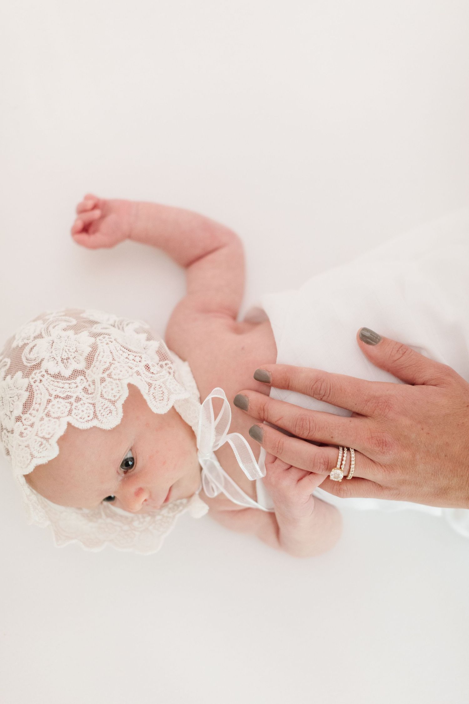 Close-up of tiny newborn wearing delicate lace headband.