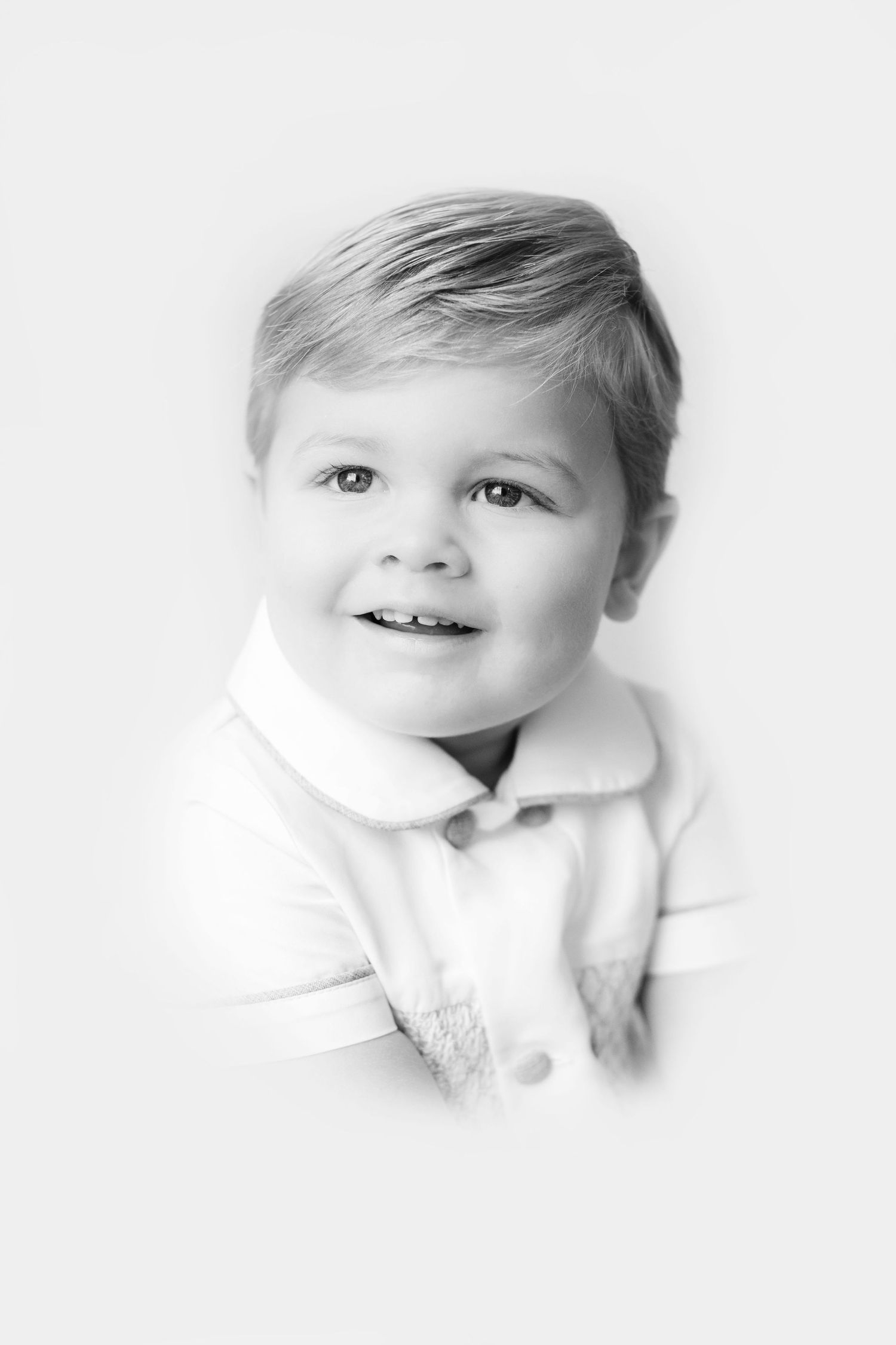 Three artistic black and white portraits of a baby in white clothing against a light background.