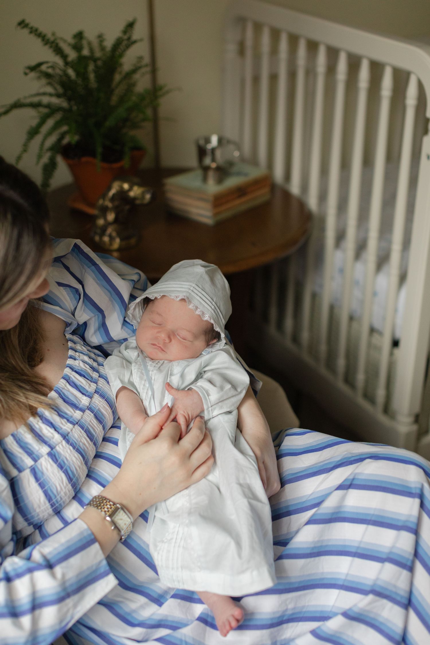 Series showing quiet moments with a newborn baby in blue and white striped bedding.