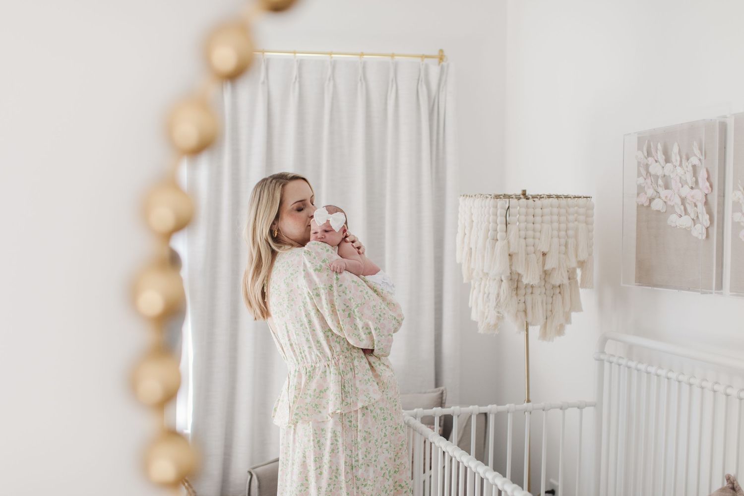 Modern white nursery with decorative macrame chandelier and natural woven accents.