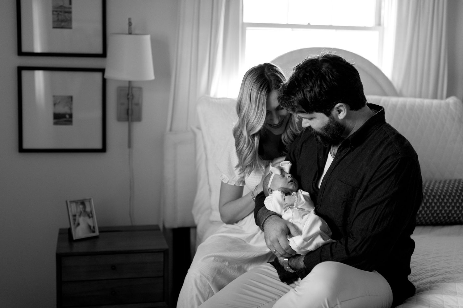 A black and white photo series showing intimate moments between a couple in a bright room with curtained windows.