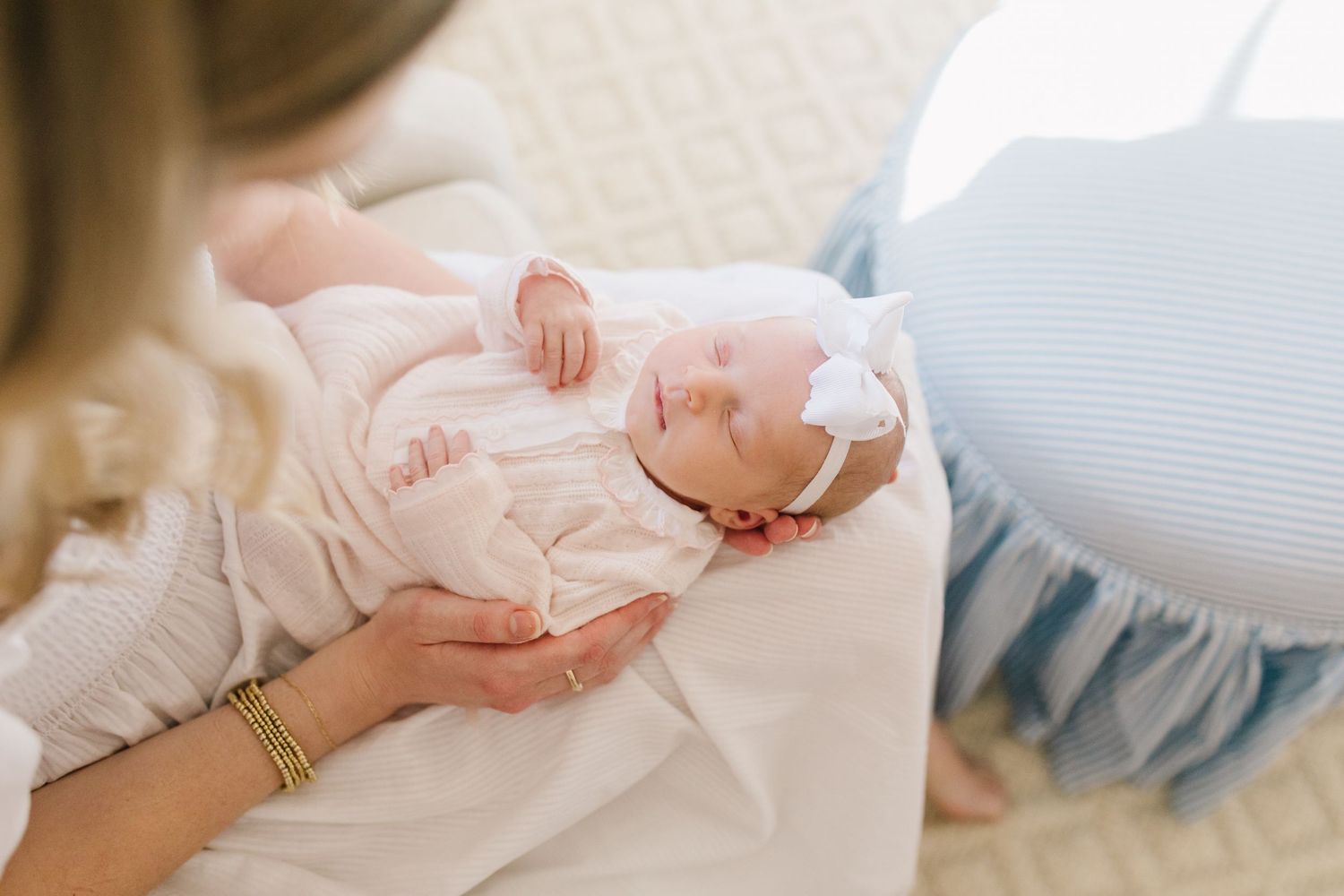 A mother and baby share an intimate bonding moment in a soft natural light setting.