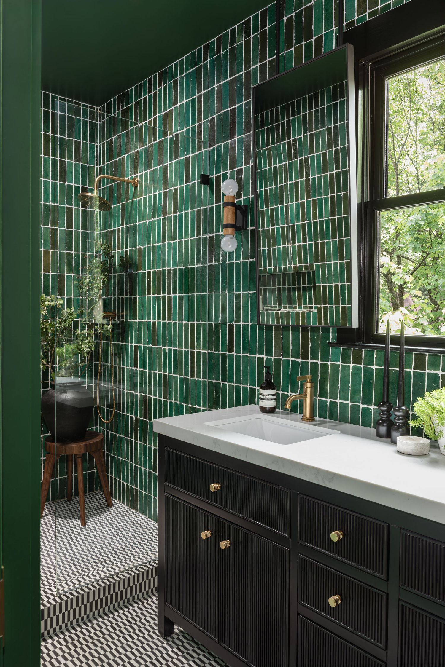 Luxurious green-tiled bathroom with black vanity and geometric floor pattern - Atlanta Interior Design Photography