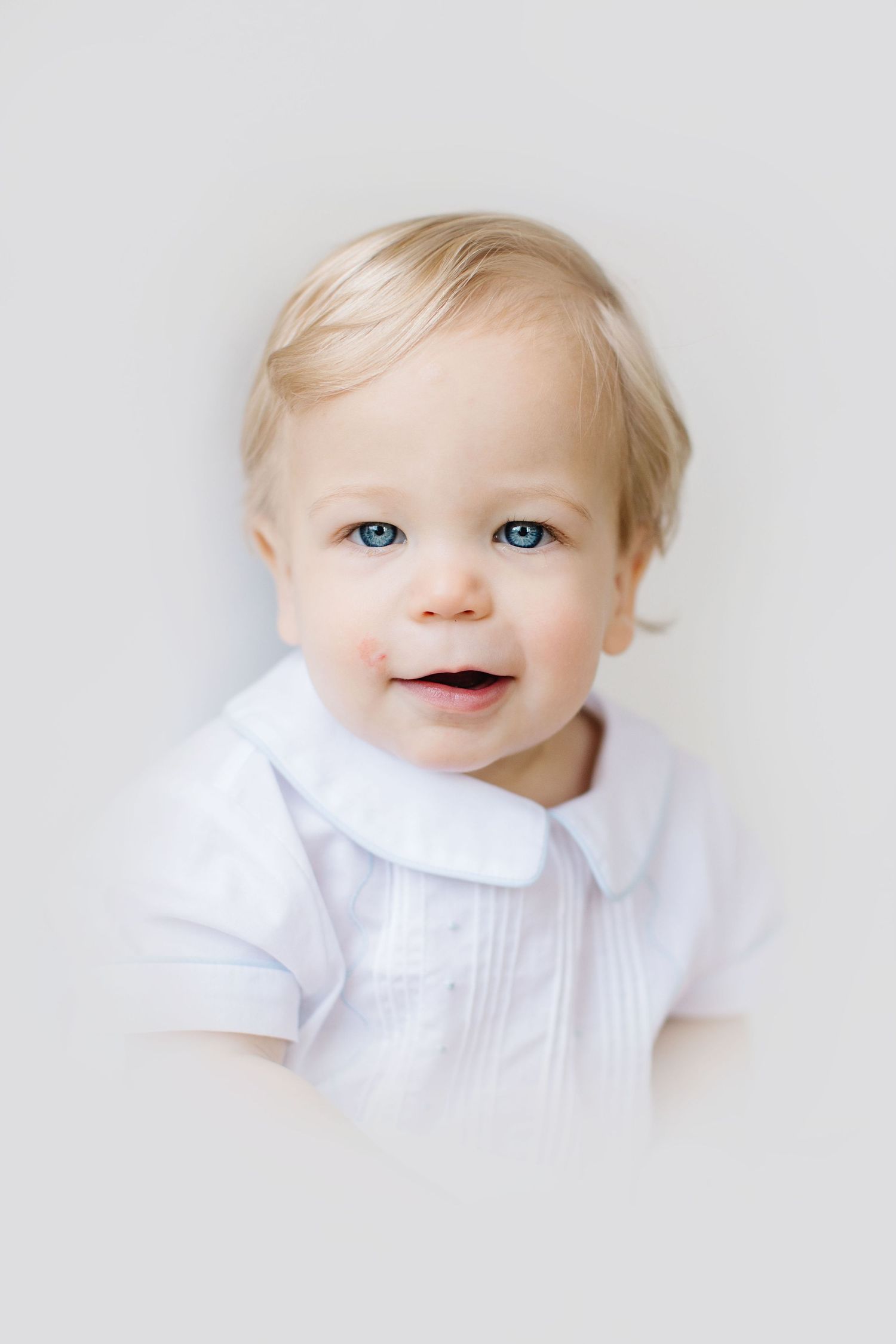 Three close-up portraits of a baby in white clothing against a light background.