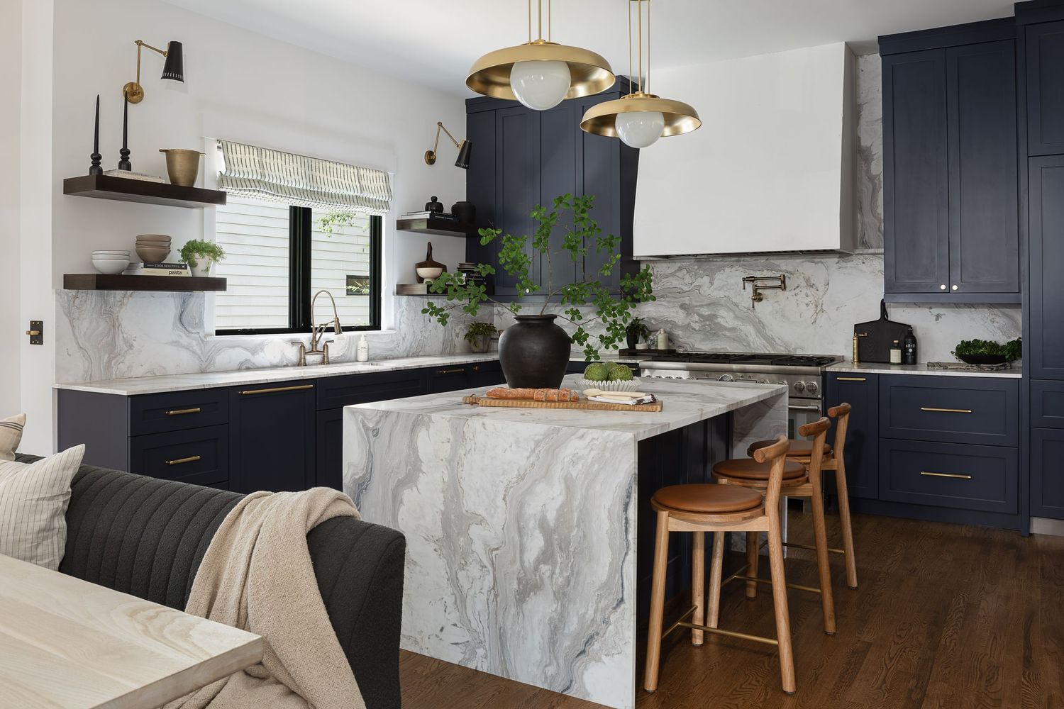 Contemporary kitchen design with black cabinets, marble waterfall island, and wooden bar stools.Atlanta Interior Design Photography