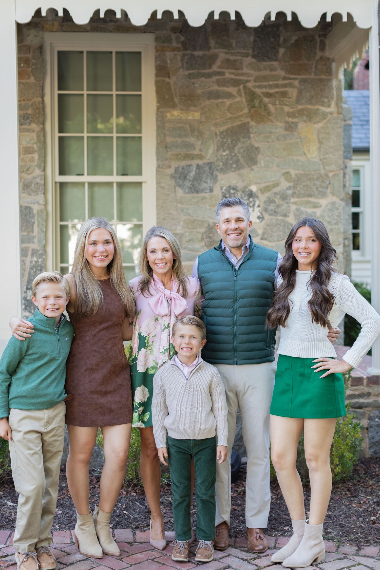 A group wearing coordinated green and brown outfits poses together on a stone porch in three similar shots.