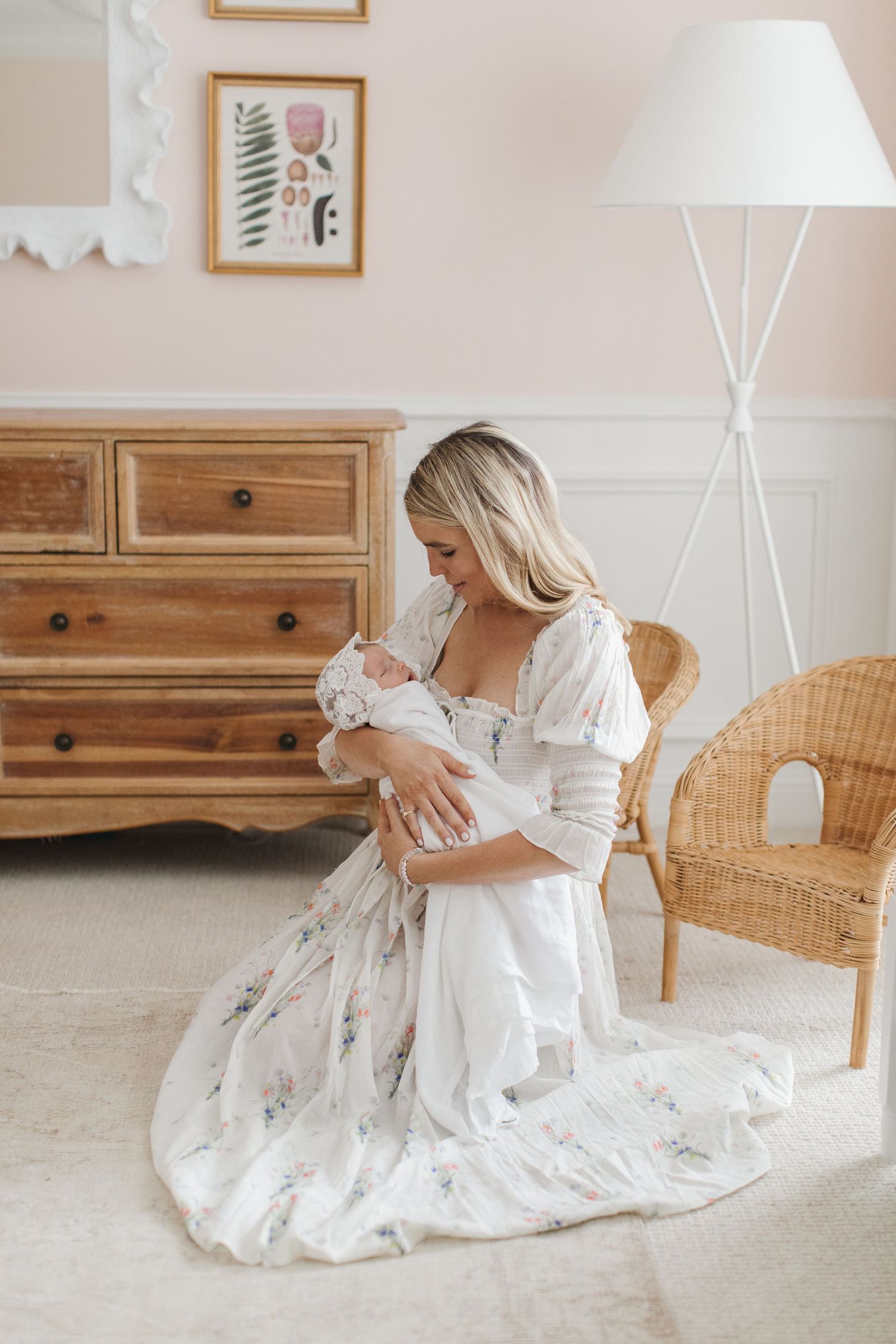 Beautiful nursery setting with wooden dresser and floral artwork.