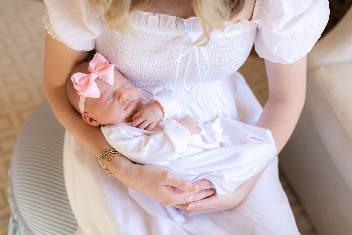 Close-up view of baby in white clothing being cradled.
