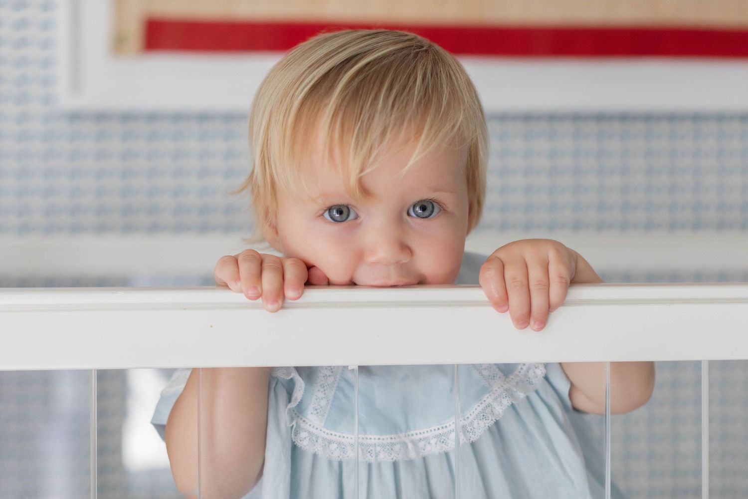 Four sequential photos show a toddler peeking over a white crib railing with playful expressions.
