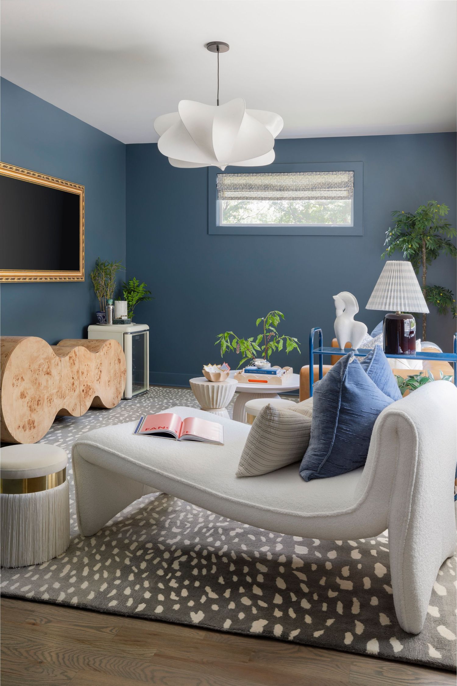 Navy blue living room with curved chaise, gold accents, and modern cloud pendant light.  Atlanta Interior Design Photography.