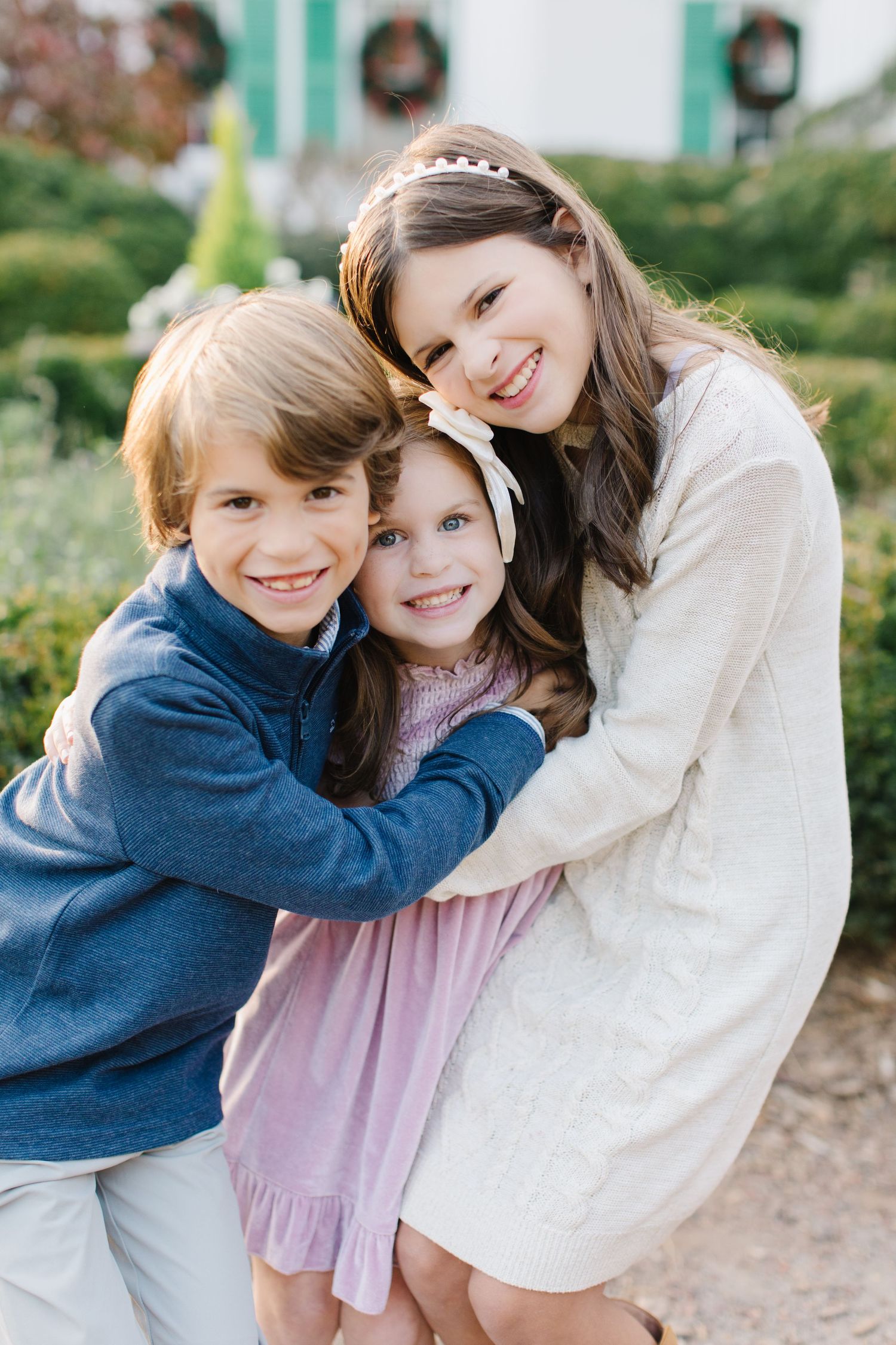 Two people in coordinating blue and white outfits share warm embraces and joyful moments outdoors during a photo session.