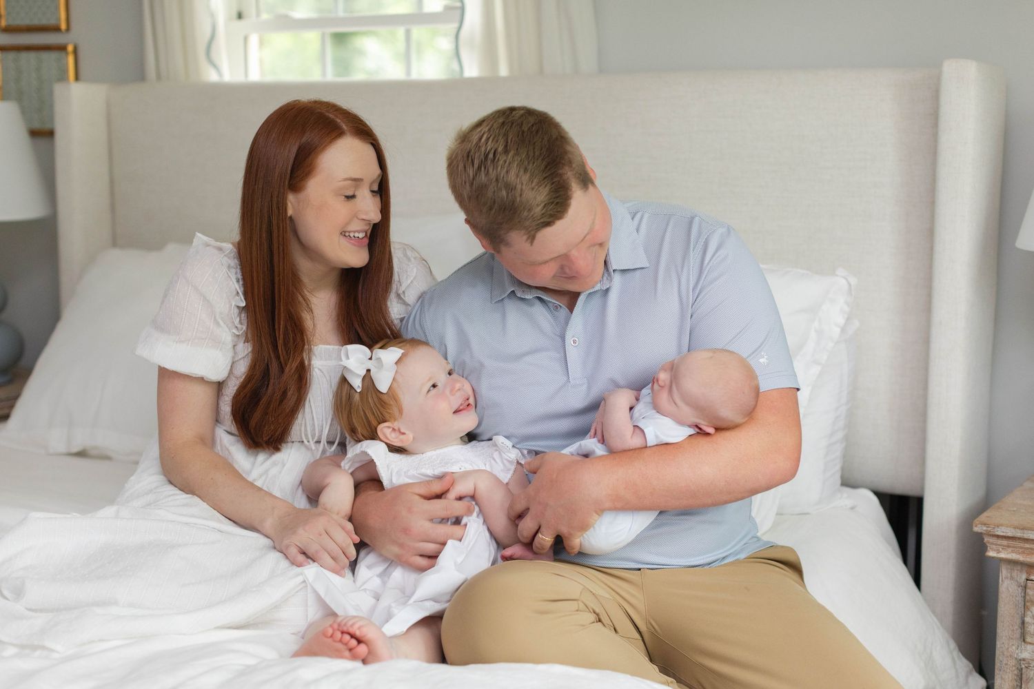 Family lounging in bed during an intimate lifestyle photography session at home.