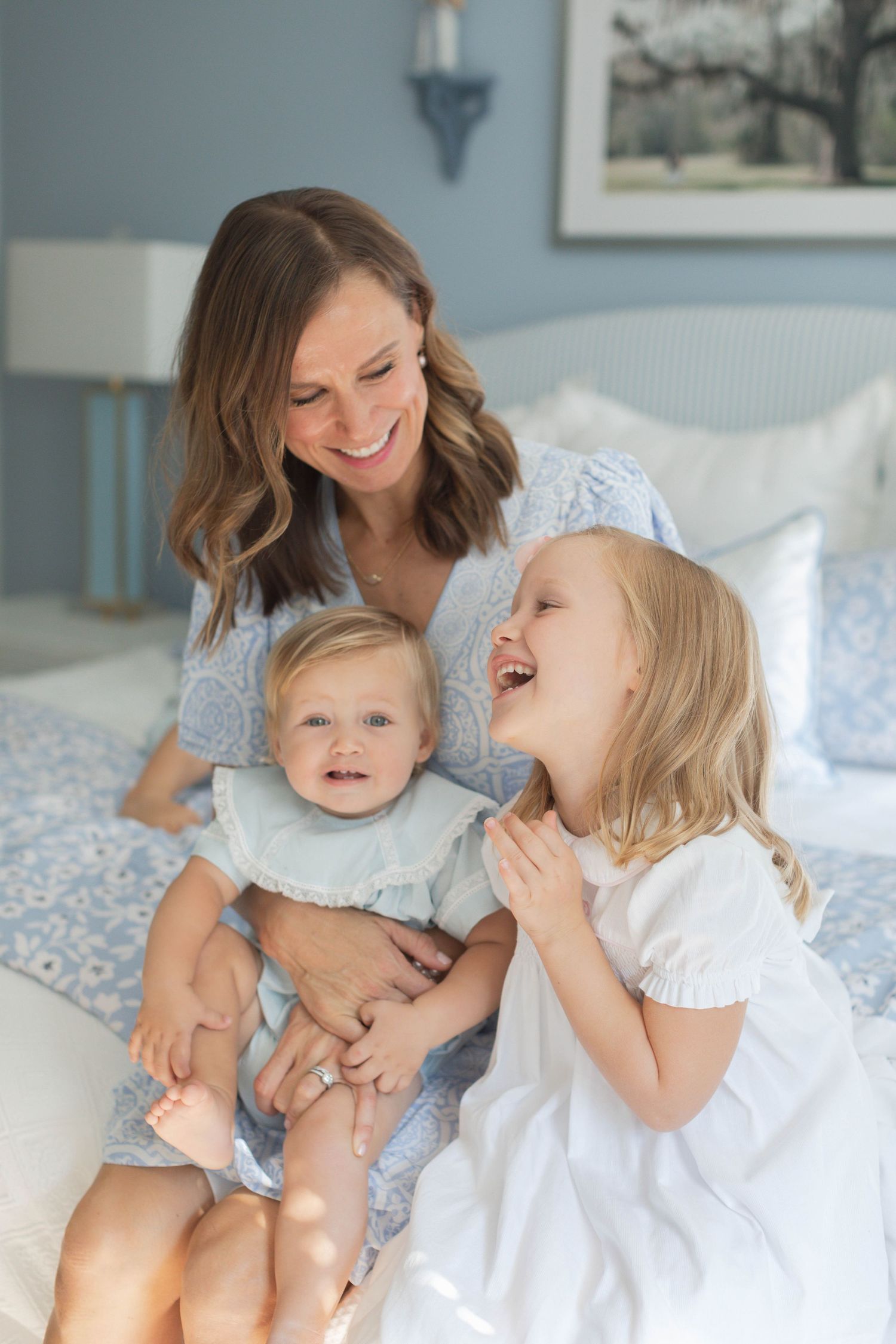 Candid lifestyle portrait of family members having fun and laughing together on a comfortable bed.