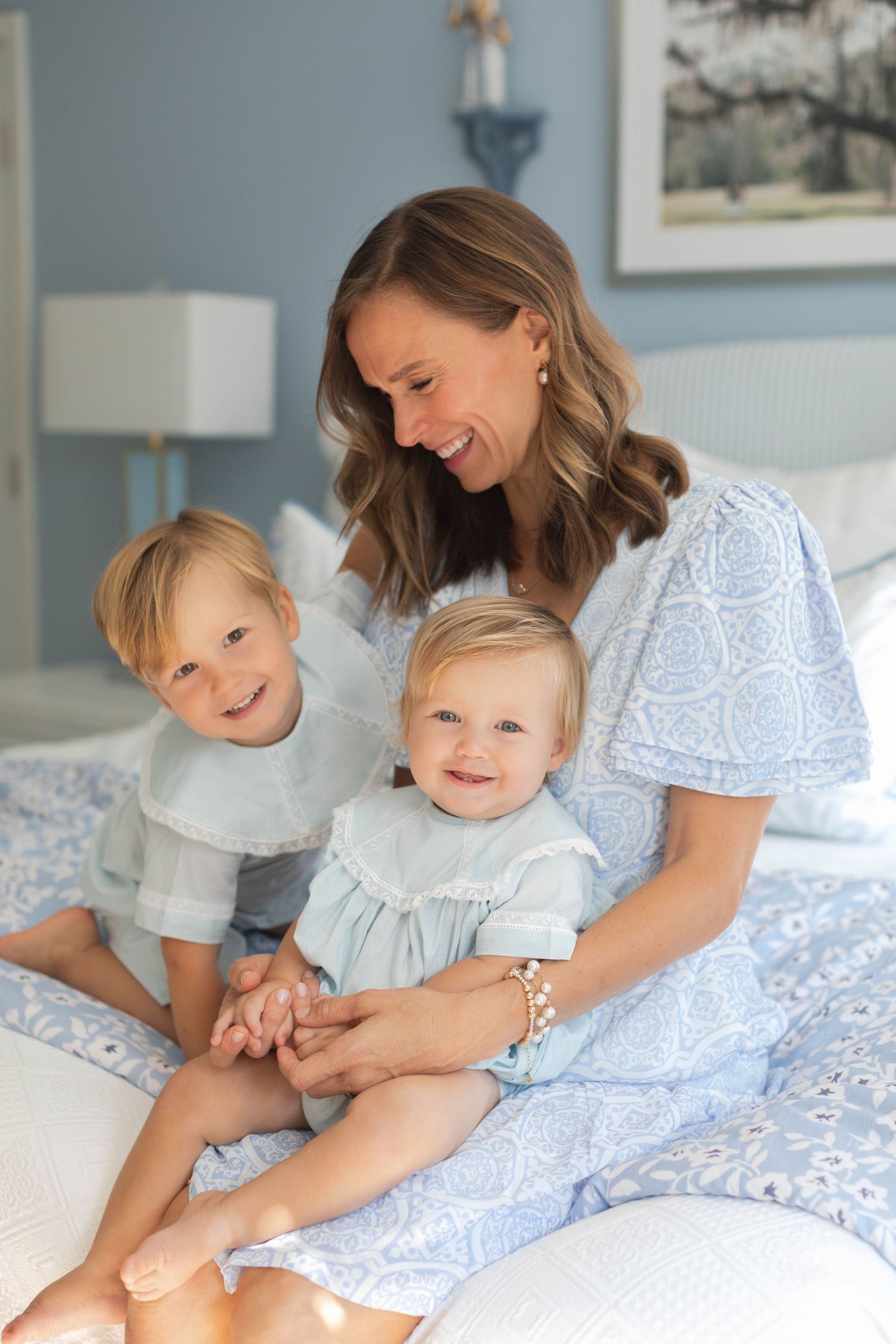 Family bonding and playing together on a blue and white bed during a relaxed morning.