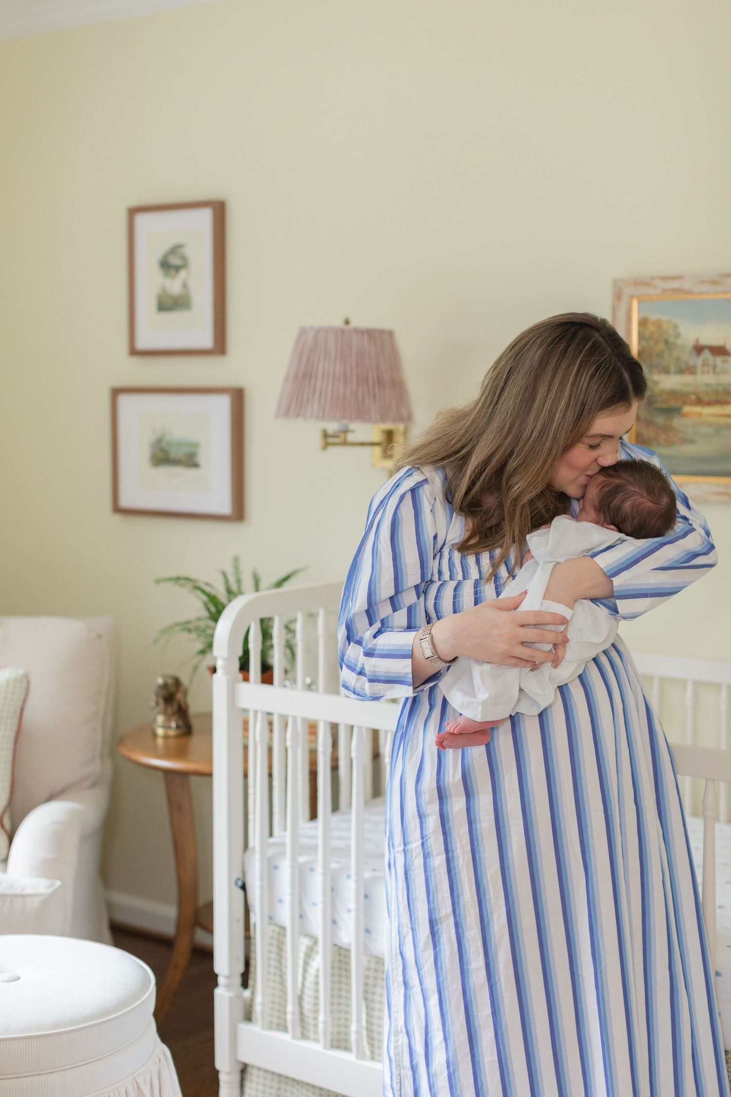 A sequence of tender moments between parent and baby in a nursery with white crib and striped clothing.