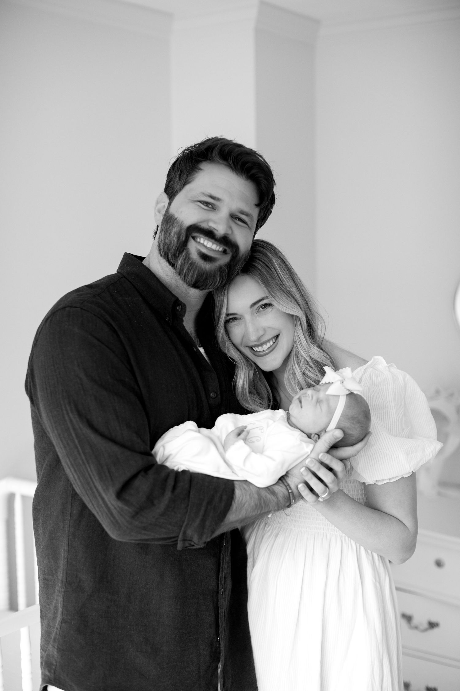 A series of black and white photos showing joyful candid moments between two people embracing and laughing together.