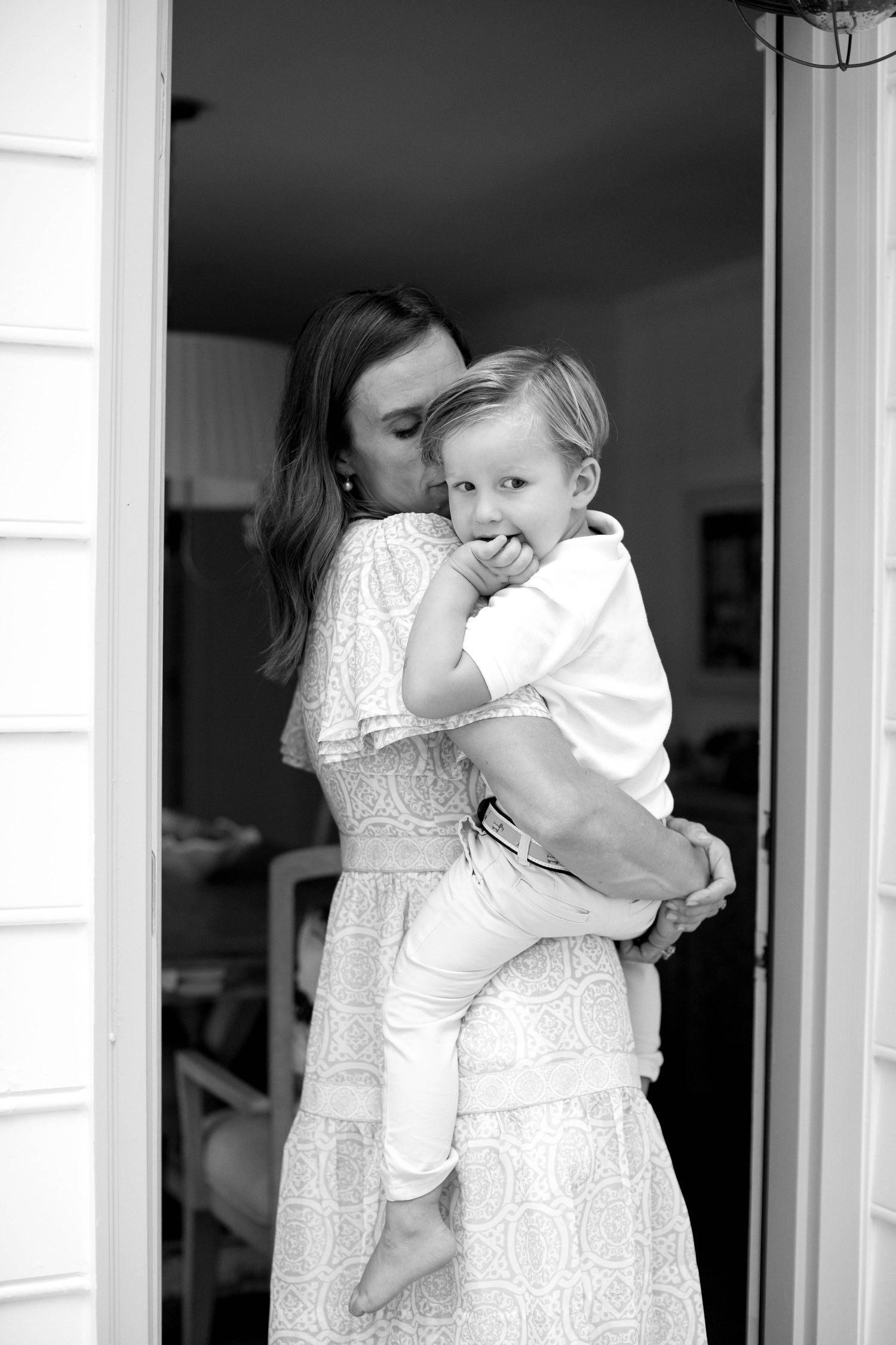 A series of candid doorway photos capturing gentle embraces in white dresses.