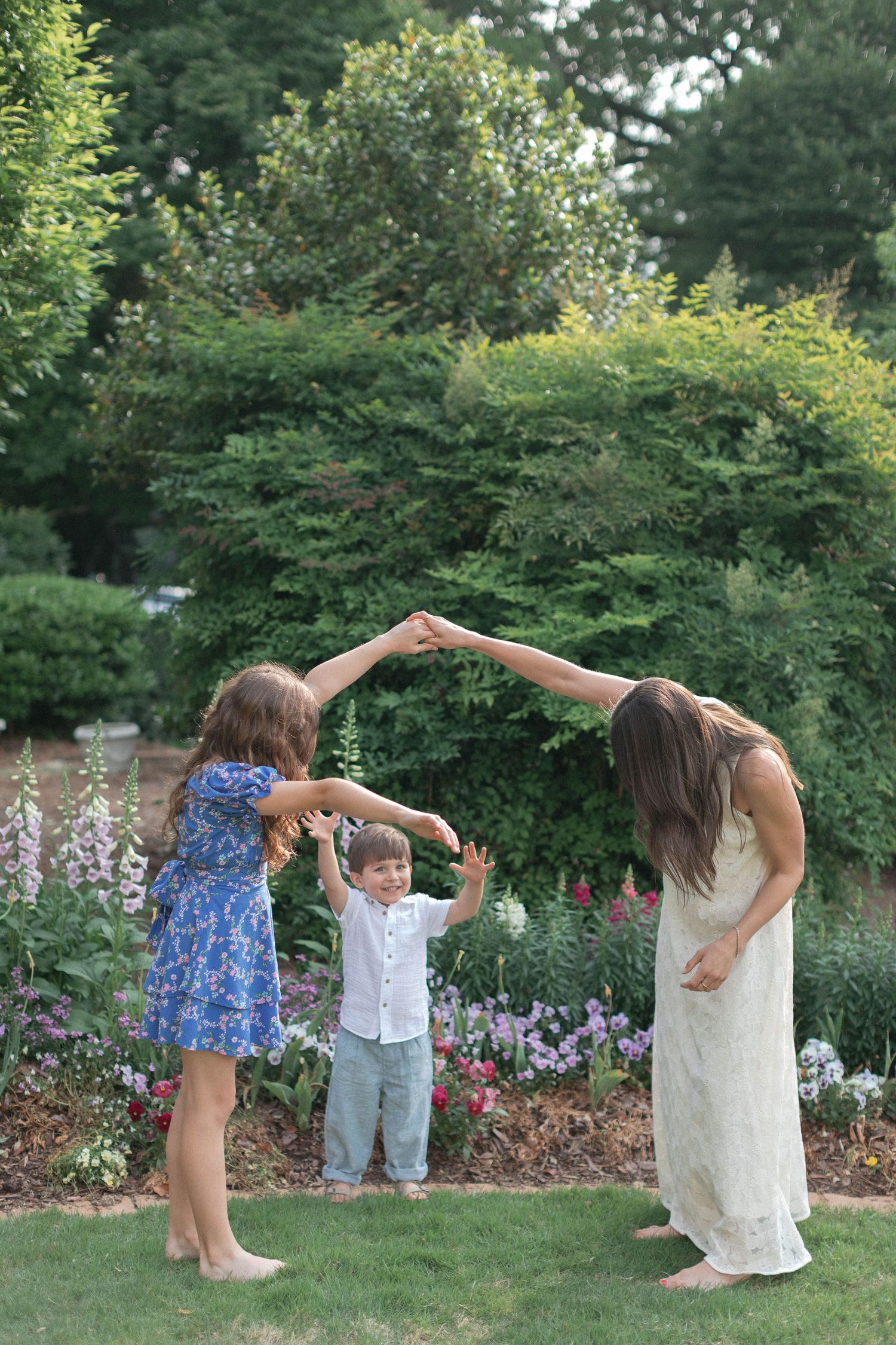 Playful dancing movements captured in a garden setting with blooming flowers and greenery.