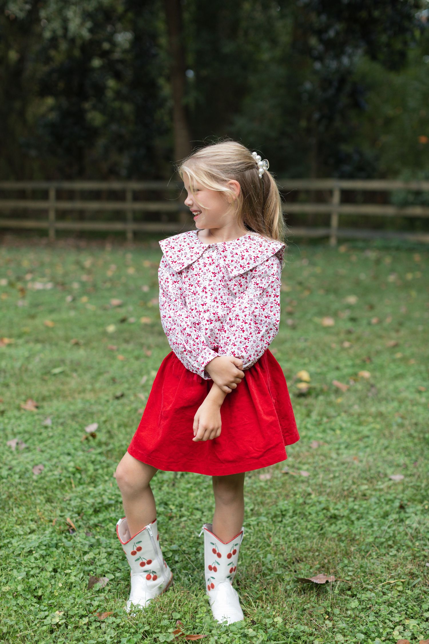A sequence of three photos showing someone in a red dress and white shoes twirling playfully on green grass.