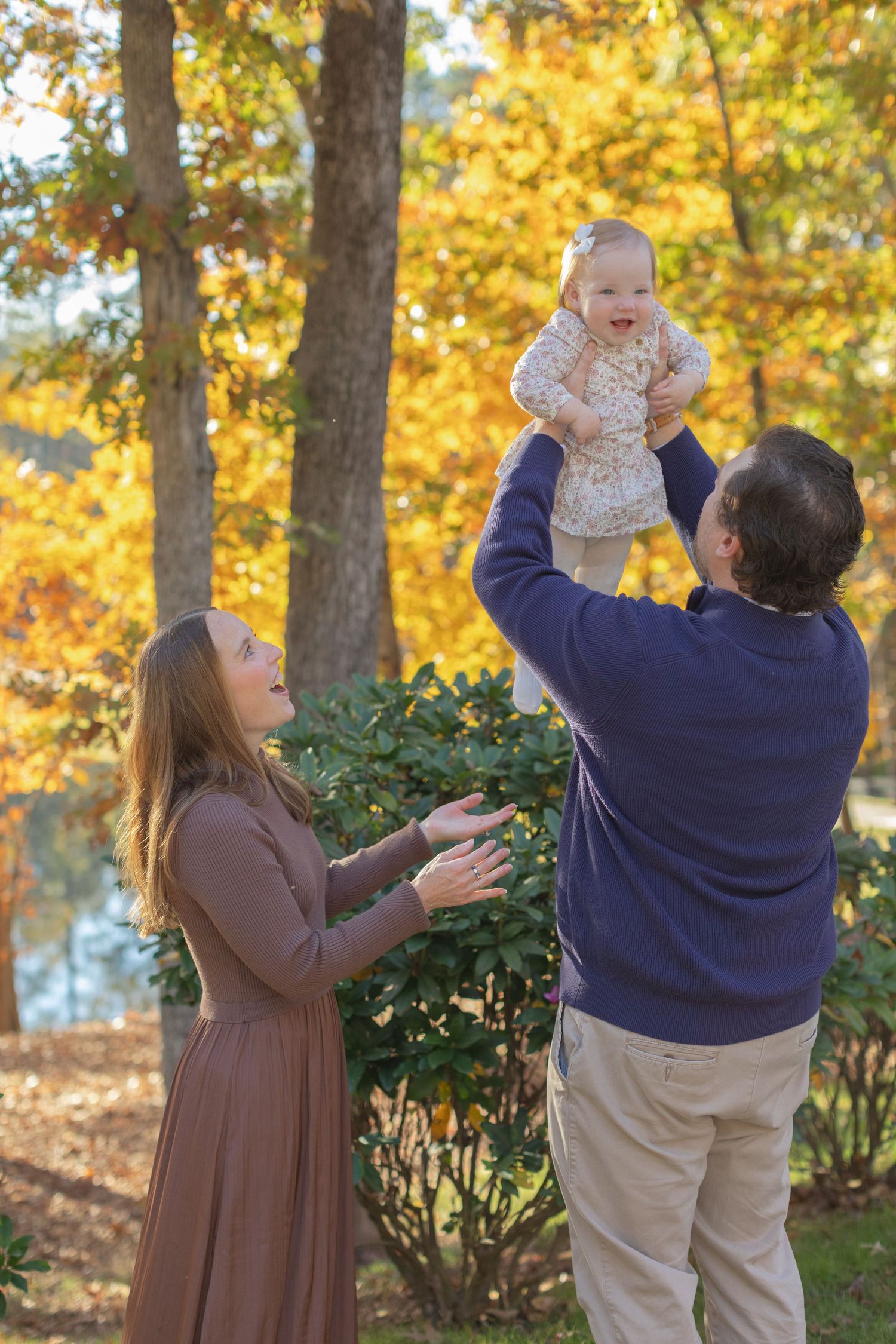 A sequence of four photos showing playful interaction between adults and a baby outdoors during autumn with golden foliage.