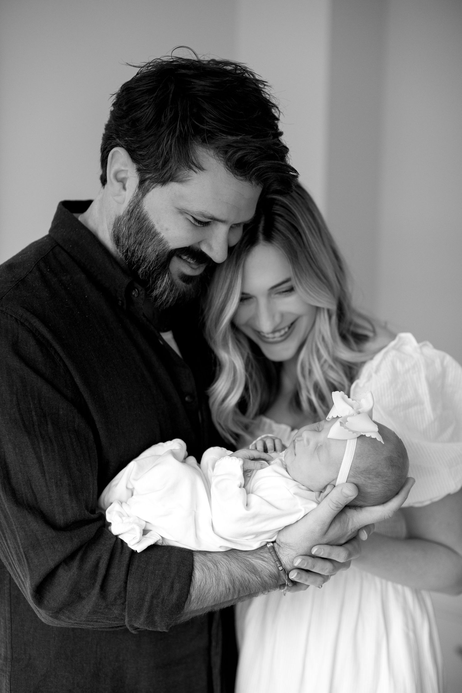Black and white series of new parents bonding with their newborn baby.