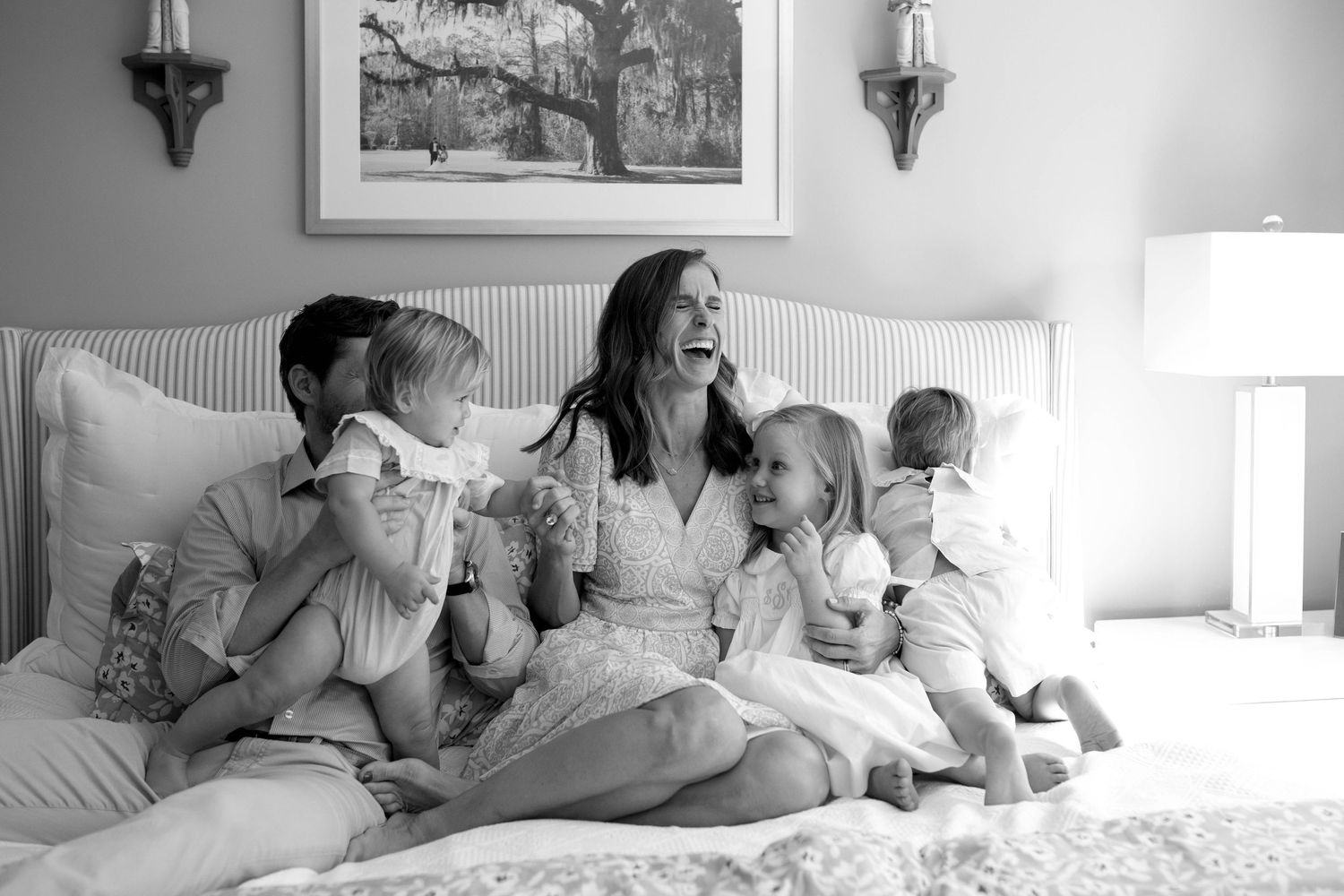 Four black and white lifestyle photos show parents and children reading together while relaxing on a bed.