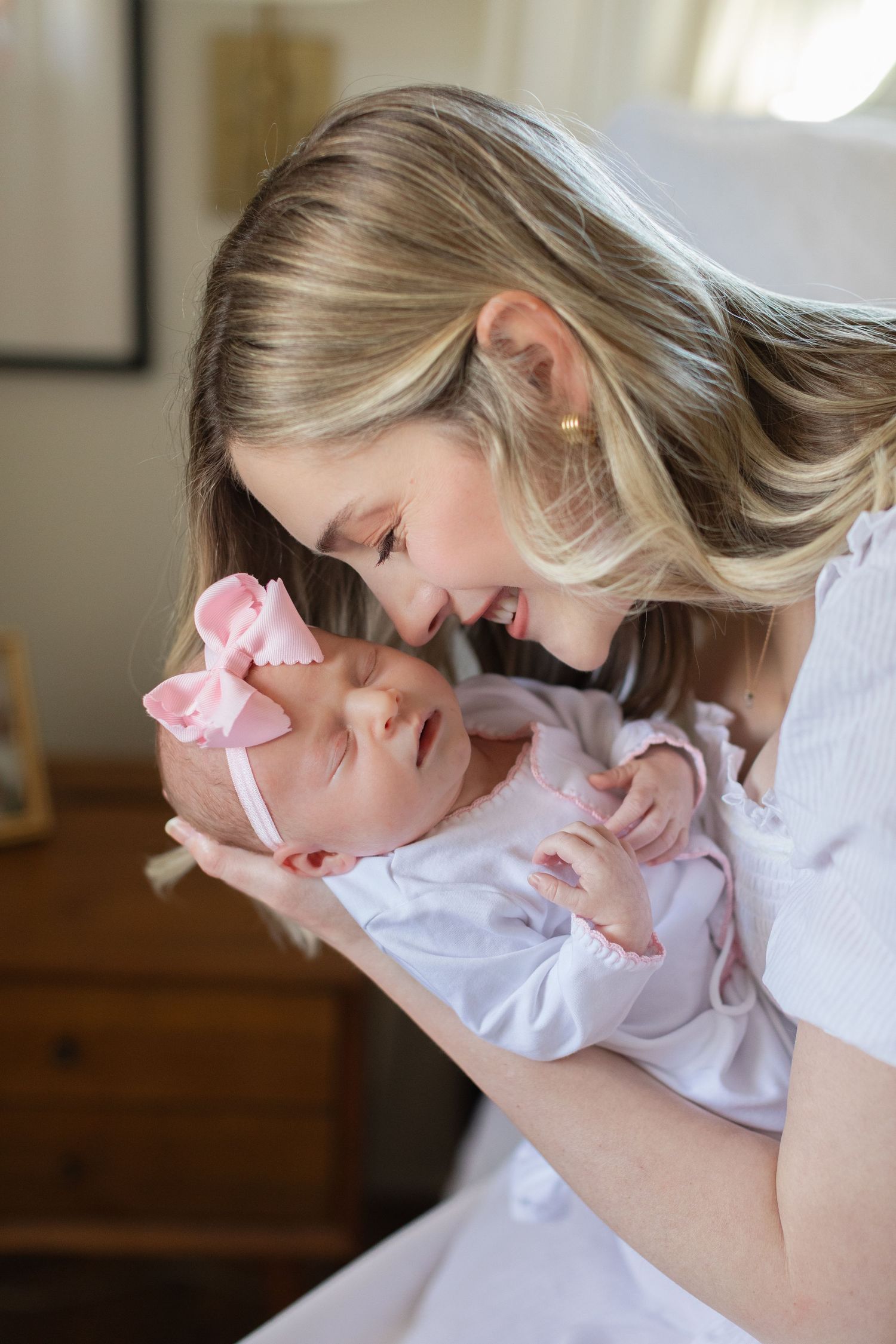 A series of tender moments showing a parent bonding with their newborn baby dressed in white.