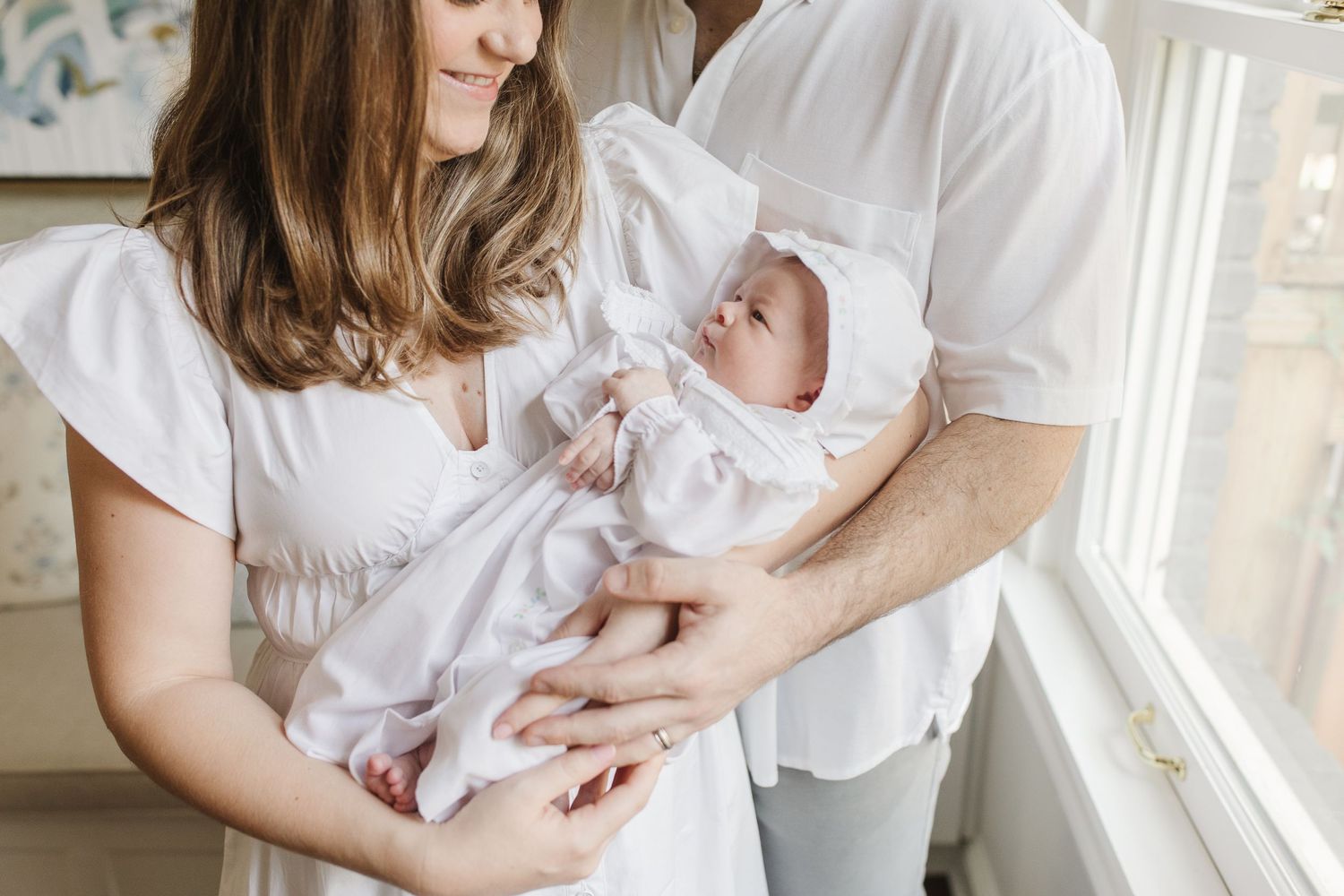 A series of tender moments captured in soft white tones against a bright window backdrop.