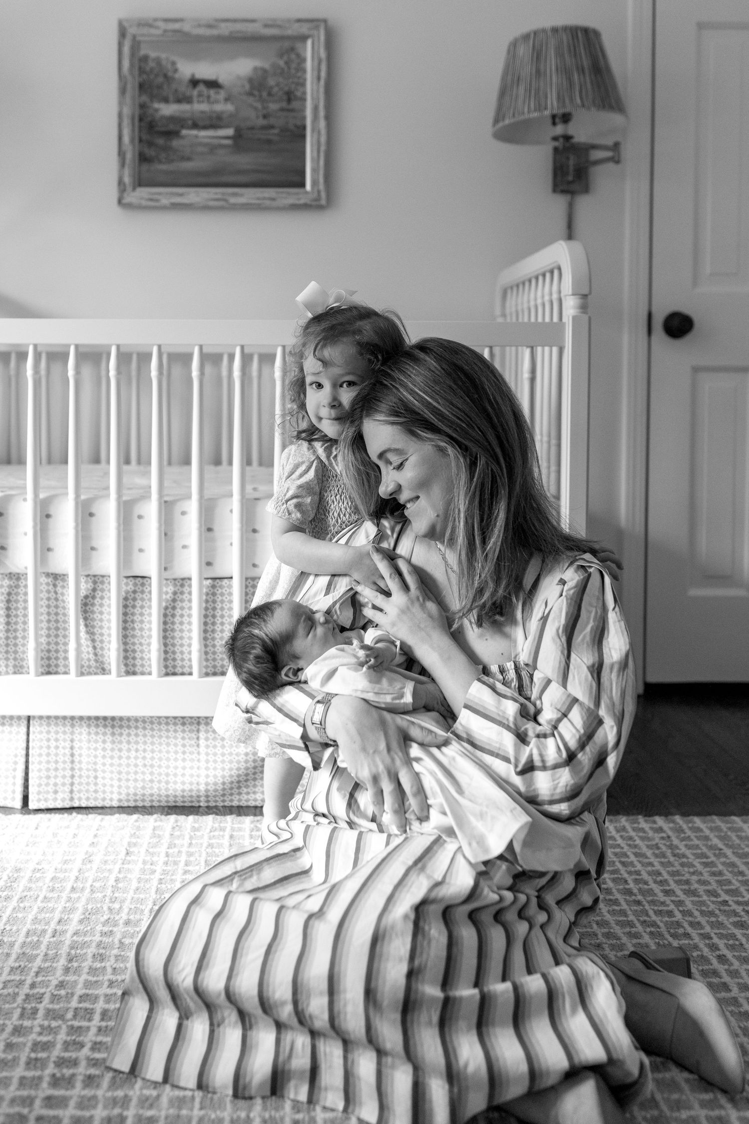 Black and white photo series showing tender moments between a parent and infant on a striped couch.
