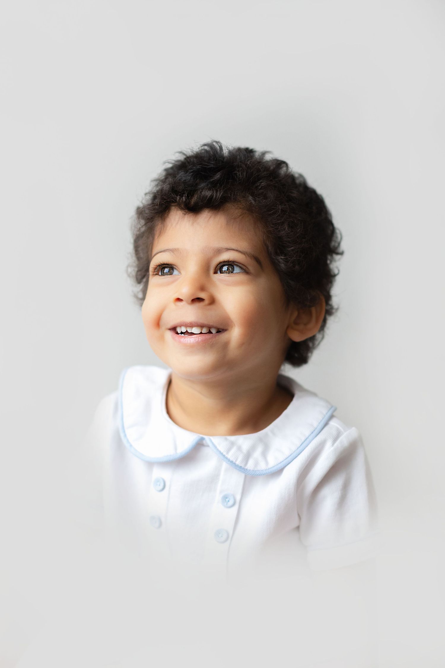 A sequence of four photos showing a child in a white collared shirt looking upward with a joyful expression.