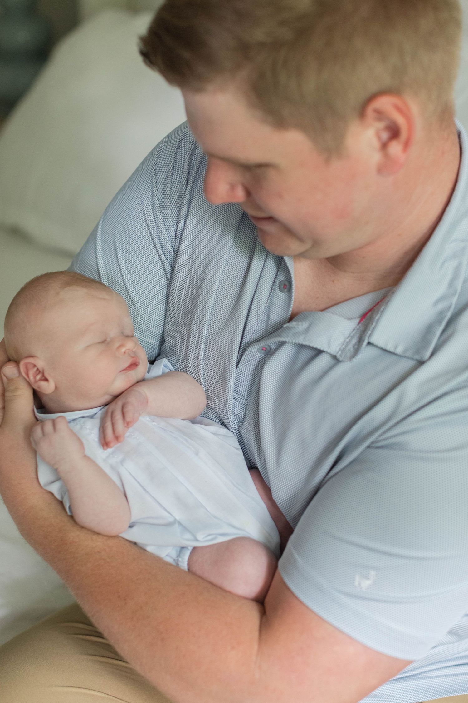 Gentle newborn photography session shows tender moments between parent and baby in soft natural light.