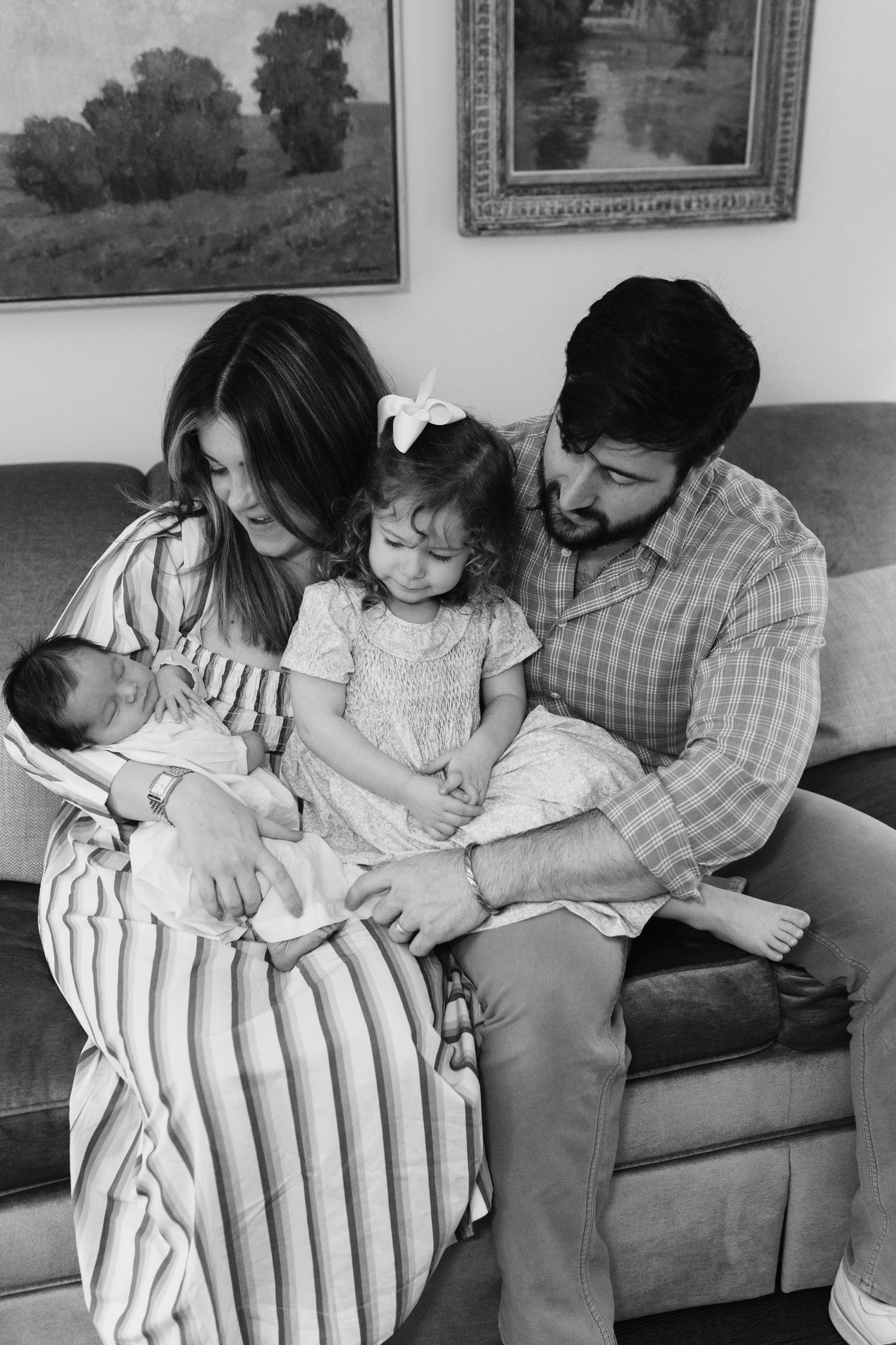 Series of intimate family moments captured in black and white on a living room sofa.