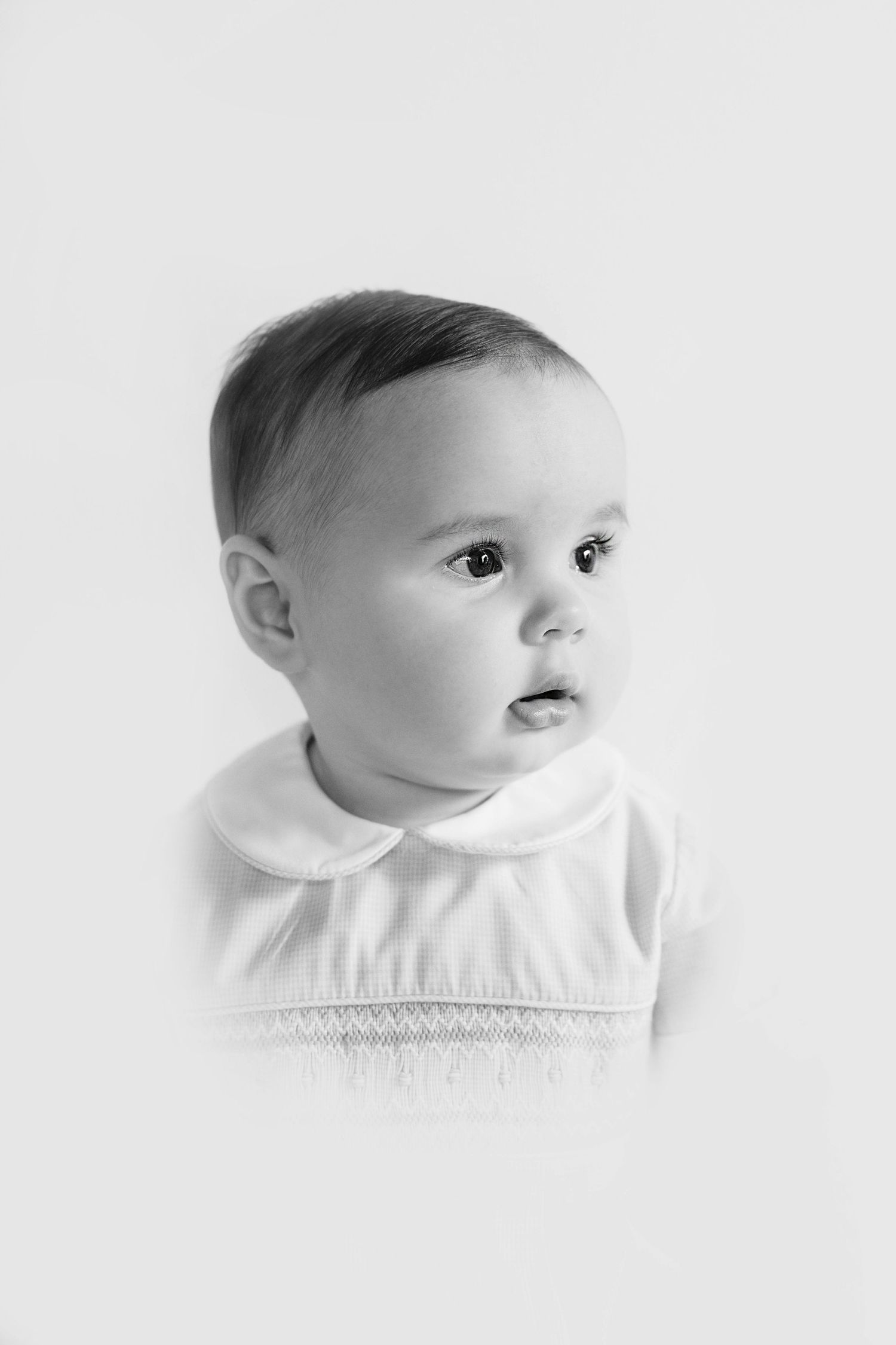 High key portrait series of an infant in white clothing against light background showing different profile angles.