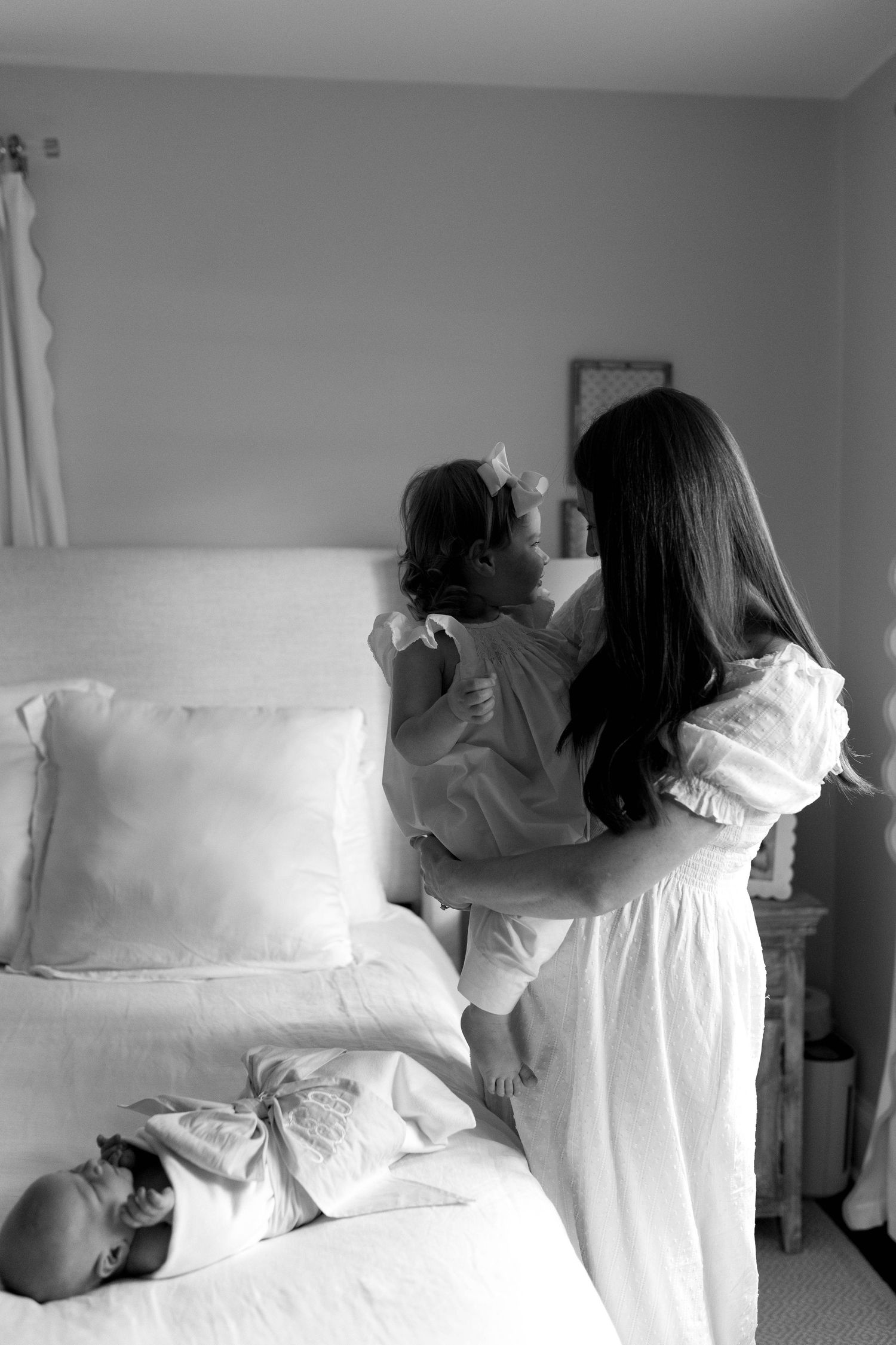 Black and white photos showing multiple playful poses with pillows on a bed.